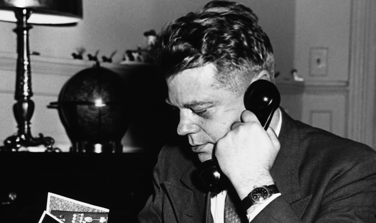 Leonarde Keeler, criminologist and lie detector inventor examining pictures of the recently discovered Kronenberg Castle crown jewels, 1946.