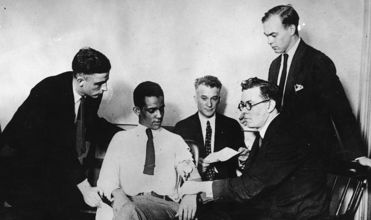 James A Frye, who is on trial for murder, undergoing a truth test using a sphygmomanometer, or lie detector, at the Washington DC Criminal Court. Left to right: Lester Wood, defendants counsel; James A Frye; James H Bilbrey, Assistant District Attorney; Dr William M MArston, deception test expert; Richard V Mattingly, defendant's counsel. 