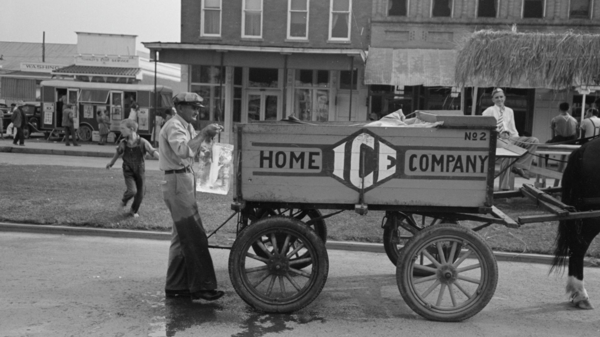 Delivering ice to stands, National Rice Festival, Crowley Louisiana, 1938. Shows iceman holding block of ice in tongs behind horse drawn ice wagon.