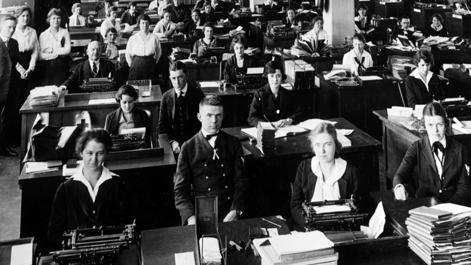 Typing pool at the Navy Department, Washington DC ca 1918-19.  Military and civilian personnel in an office in the Main Navy or Munitions Buildings. Many of the women present are Navy Yeomen (F). Note the two male Chief Yeomen at the first two rows of des