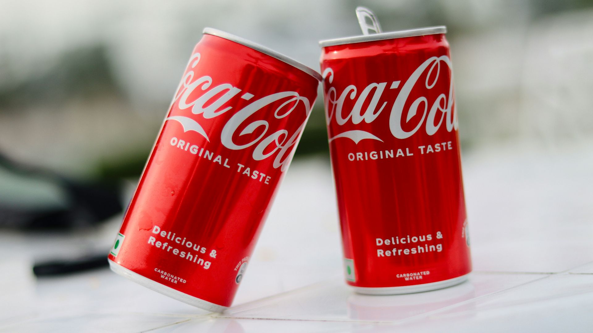 two cans of coca cola sitting on a table