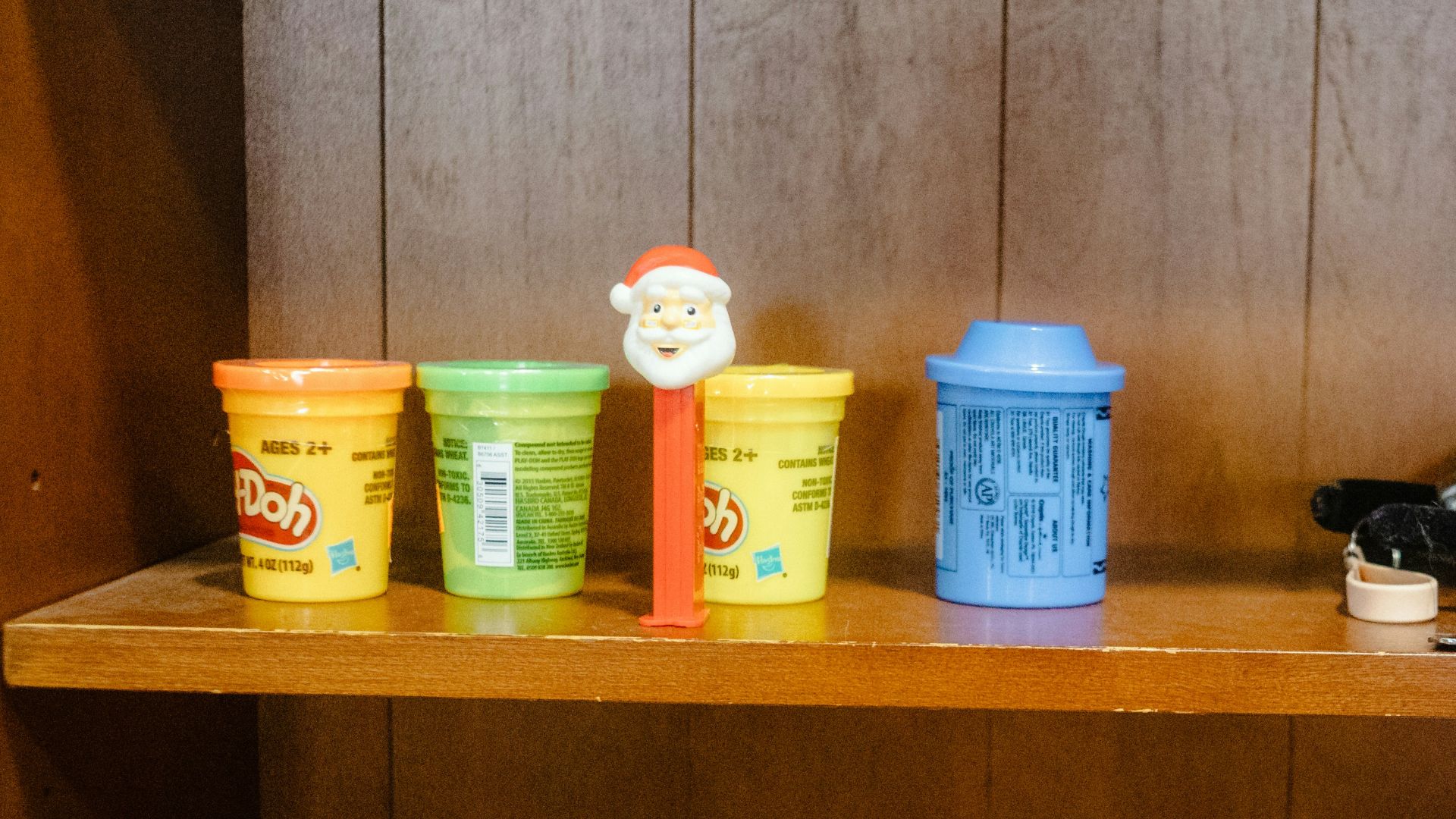 Toys and craft supplies on wooden shelves.