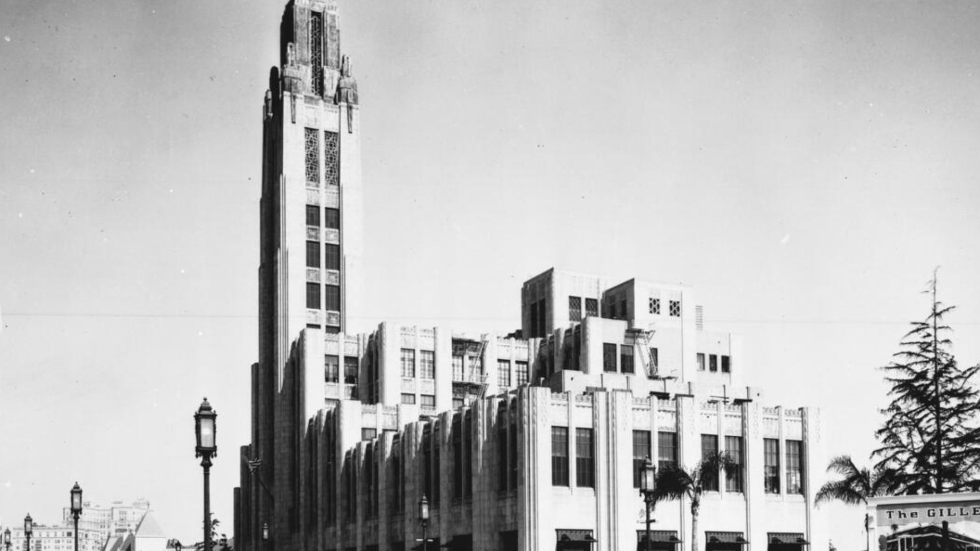 Photograph of the exterior of the Bullock's Department Store on Wilshire Boulevard,  taken from down the street, ca.1936. This famous five-story art deco building, with its two-hundred and forty-one foot tower and penthouse accented with verdigris copper,