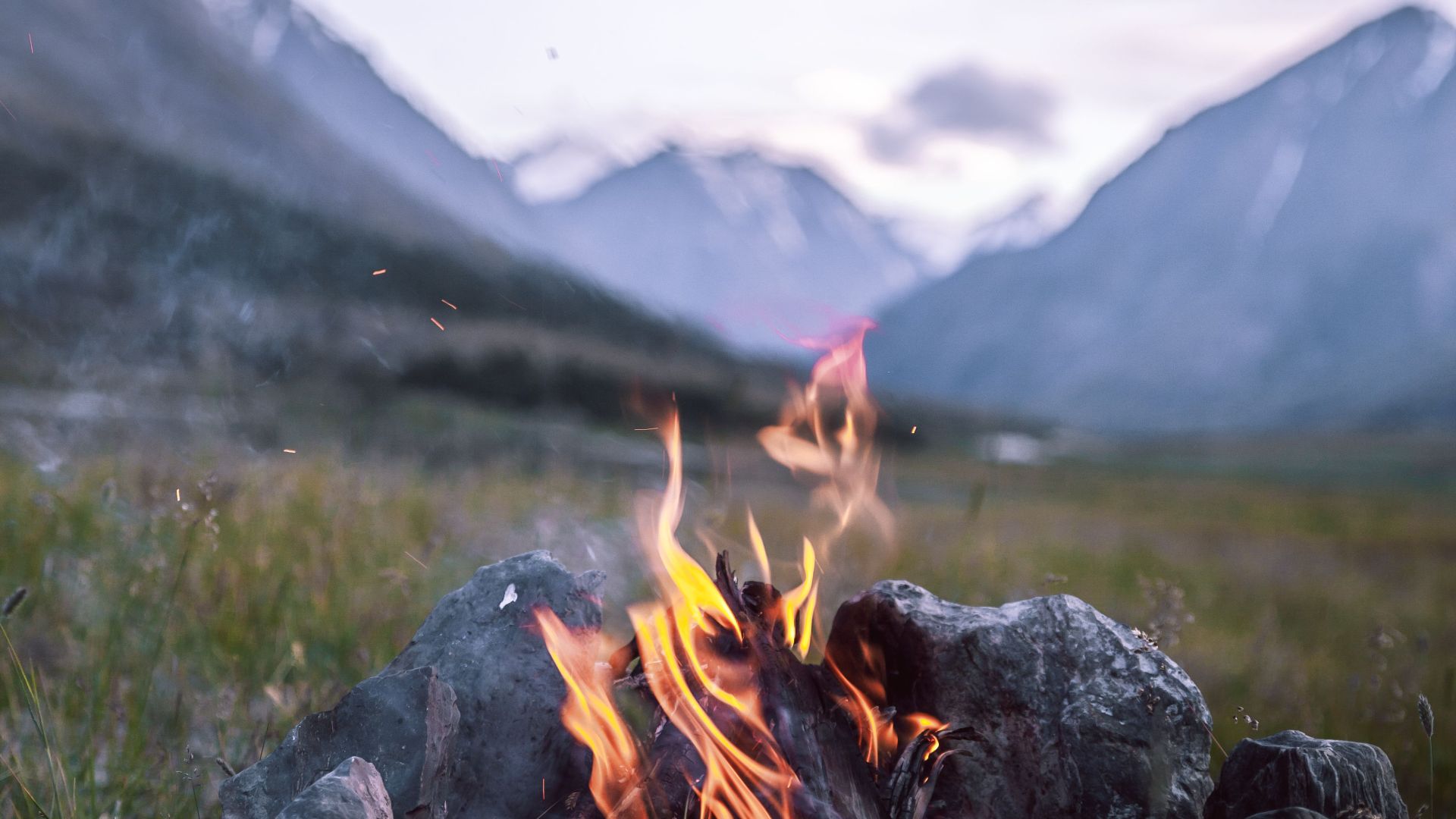 Serene campfire amid majestic mountains, perfect for nature and travel themes.