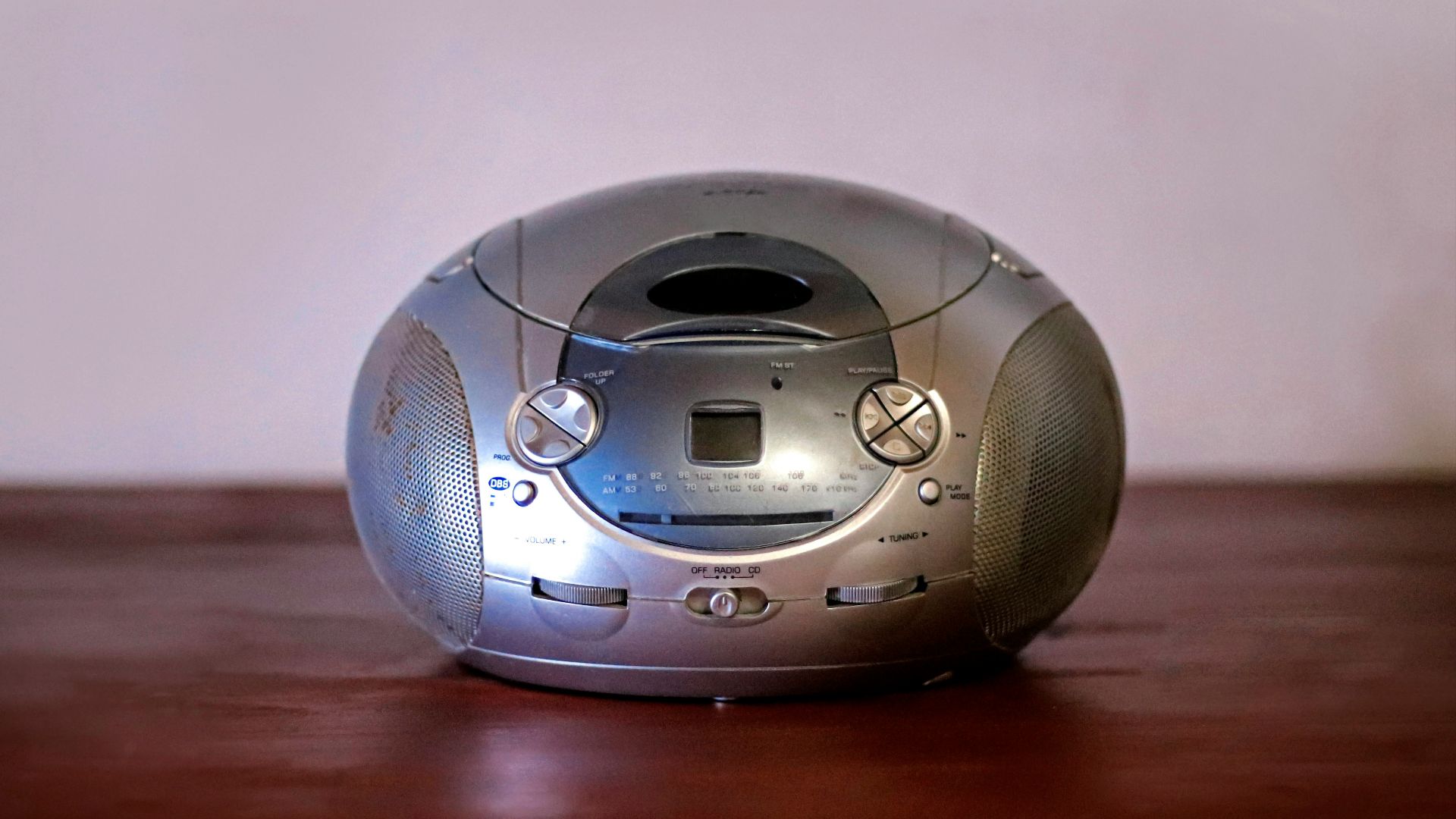 A silver alarm clock sitting on top of a wooden table