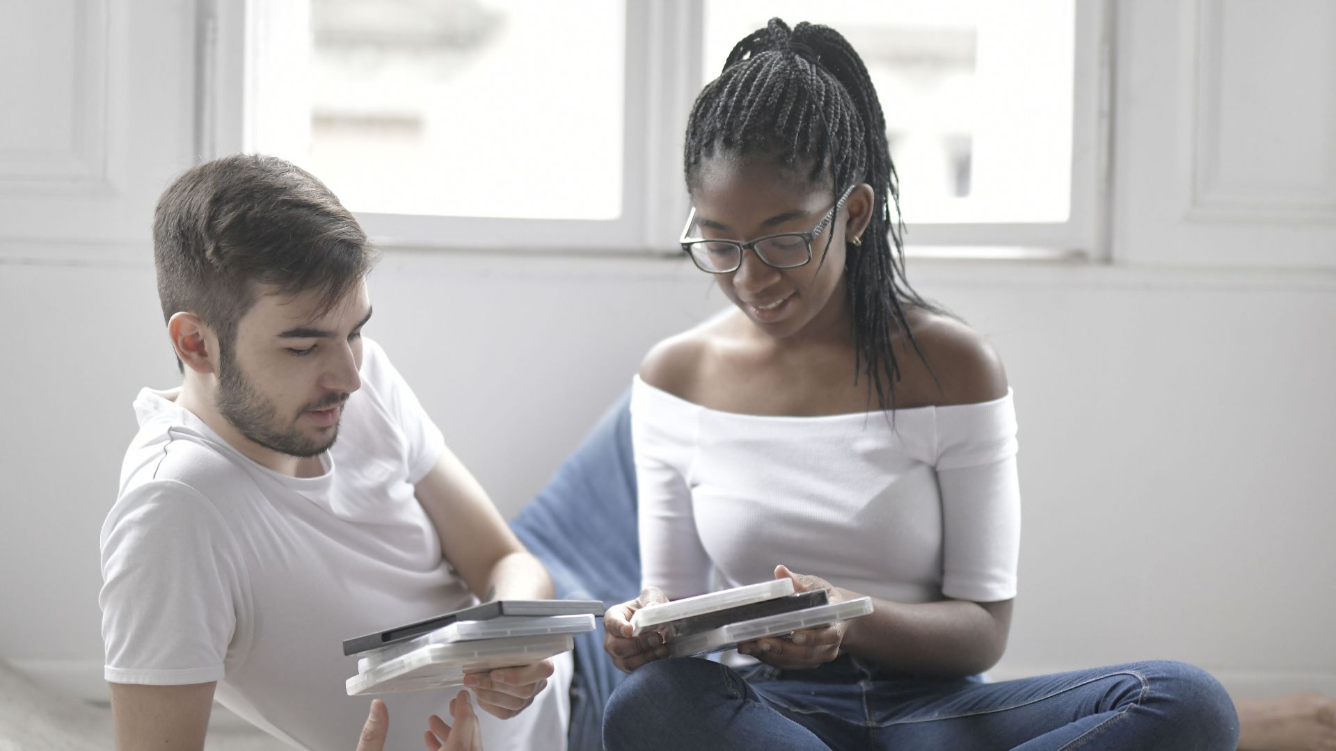 Young couple relaxing at home, choosing movies for a cozy night in.
