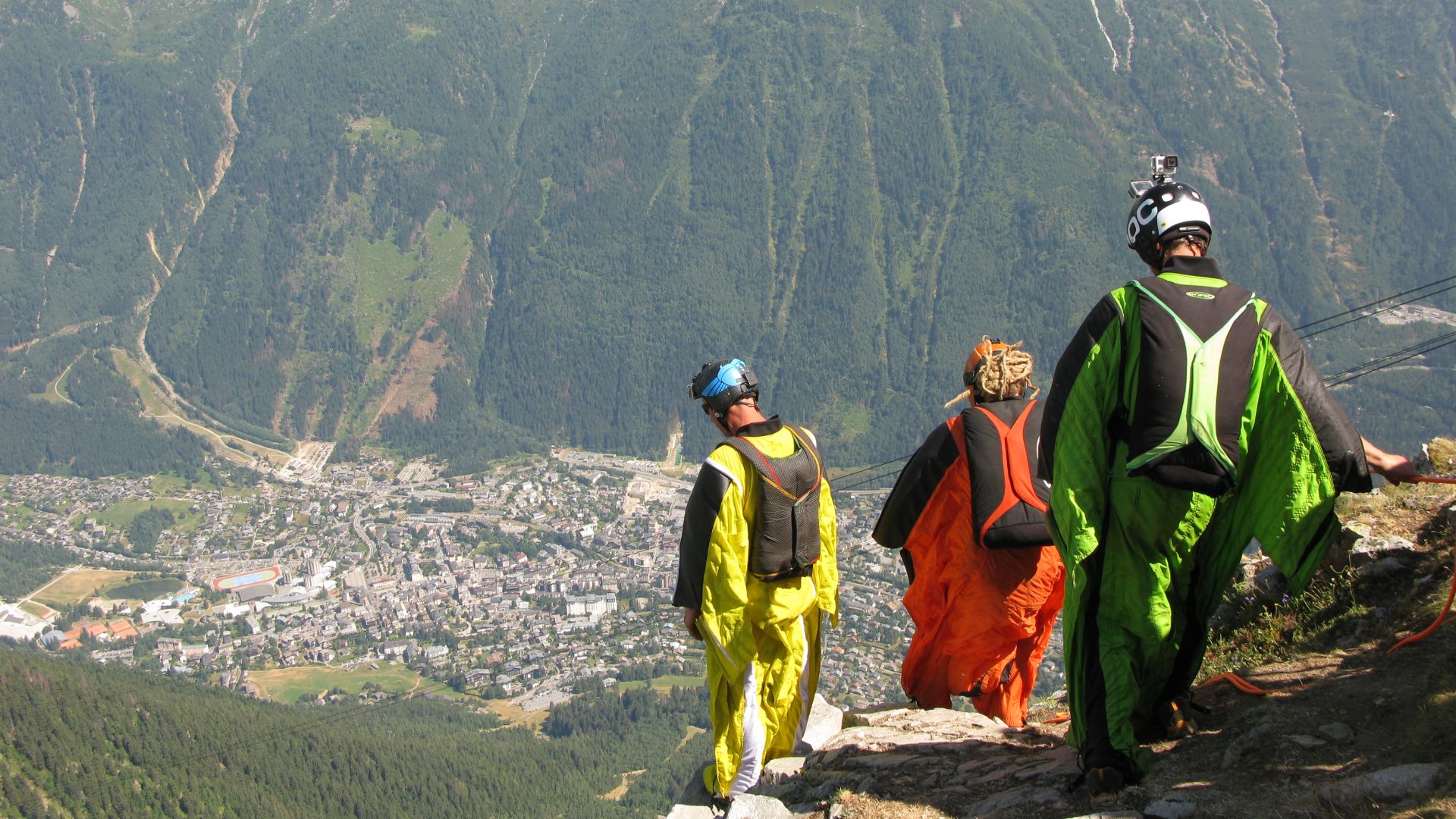 Three Wingsuit BASE jumpers getting ready to jump at an exit point in France.