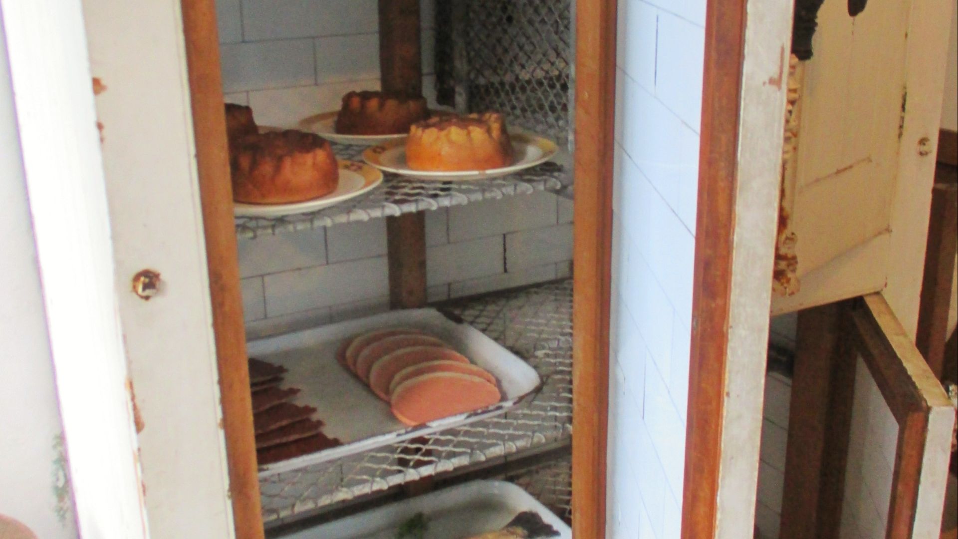 This early refrigerator kept food fresh by cooling it with ice held in the cage in the top right. The ice came from the ice house which was stocked in winter with ice from ponds and lakes.