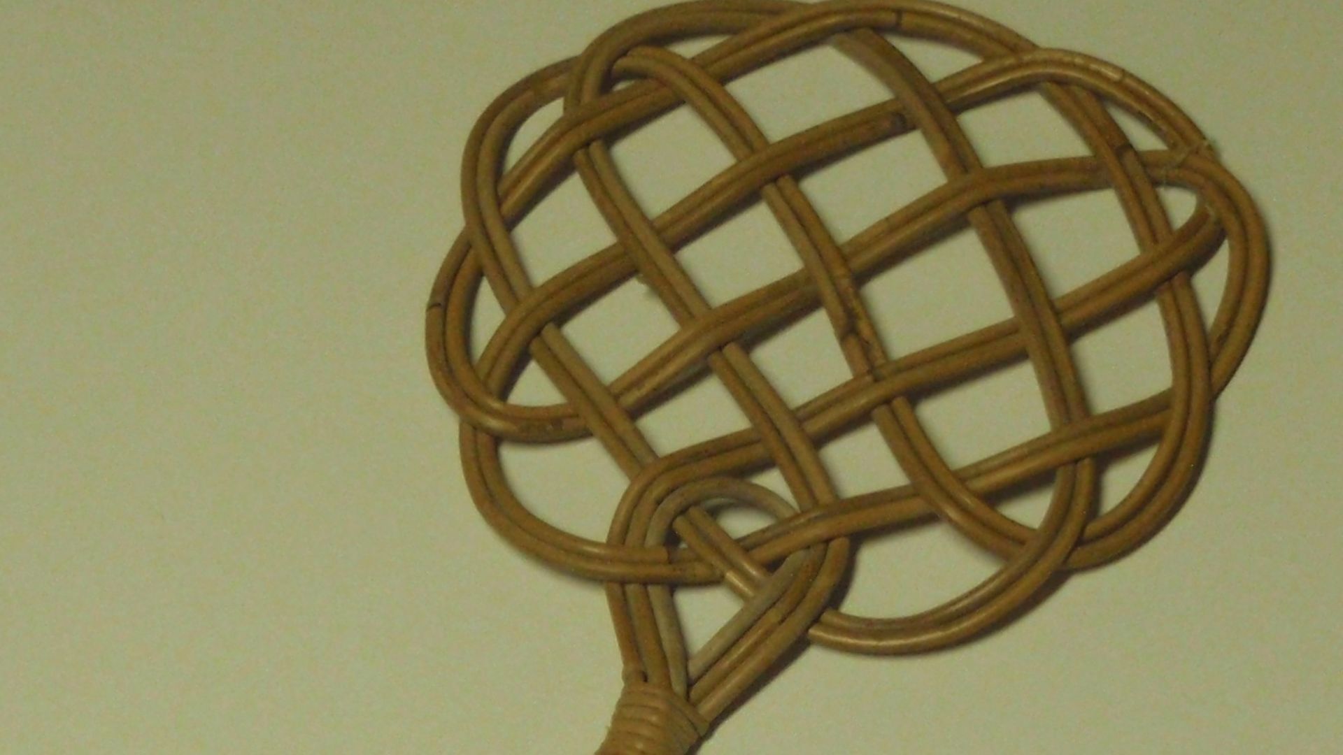 old fashioned carpet beater made of rattan