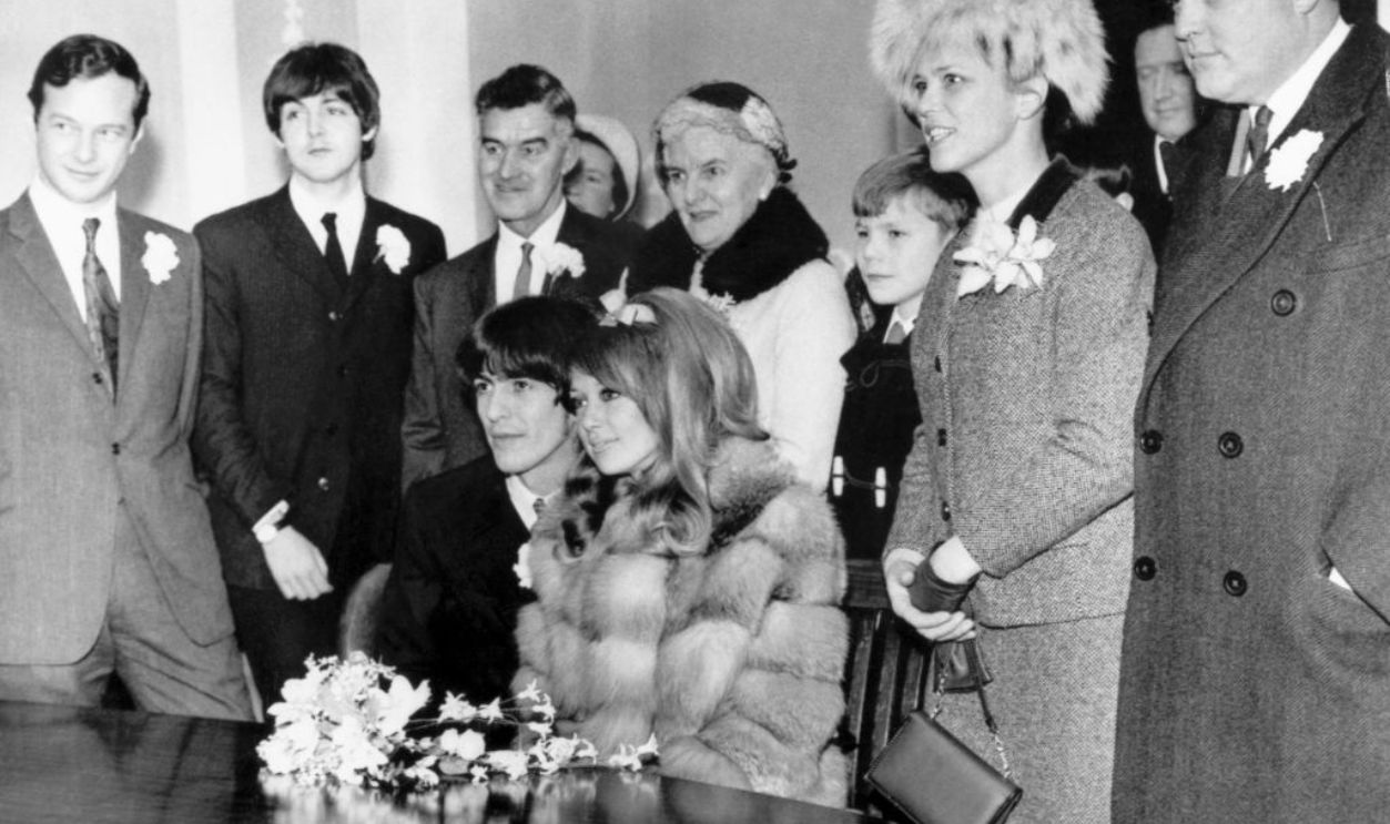 UNITED KINGDOM : The seated newlyweds pose for the camera surrounded by family and friends including the Beatles's manager Brian Epstein (far left), Paul McCartney and the bride's brother and mother. Harrison met Boyd on the set of ?A Hard Day?s Night? in 1964 and married her in early 1966. Boyd inspired Harrison to write many songs including ?Something? from the Beatles?s ?Abbey Road? album. They divorced in 1977 and Boyd married the guitarist Eric Clapton (1945-) two years later. George Harrison (1943-2001) formed the Beatles in 1960 with Paul McCartney (1941-), John Lennon (1940-1980) and Ringo Starr (1940-) in Liverpool, England. They went on to become the most successful pop group of all time and finally split in 1970. 