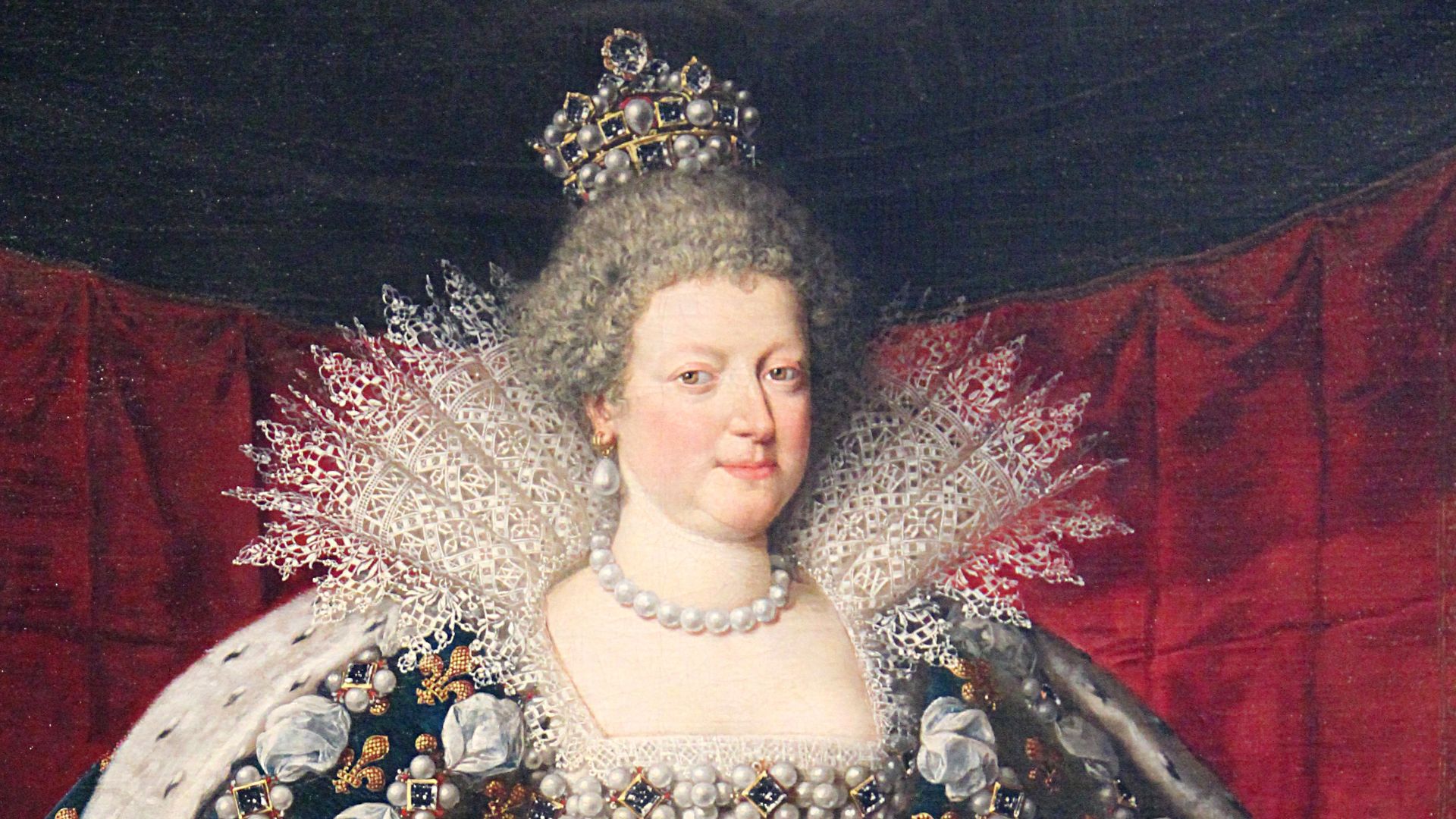 Marie de Médicis en costume d’apparat (robe aux manches crevées avec le col de dentelle « à la Médicis », corsage de soie blanche orné de pierreries et de perles, manteau royal en velours de soie bleu orné de semis régulier de fleurs de lys dorées,  doubl