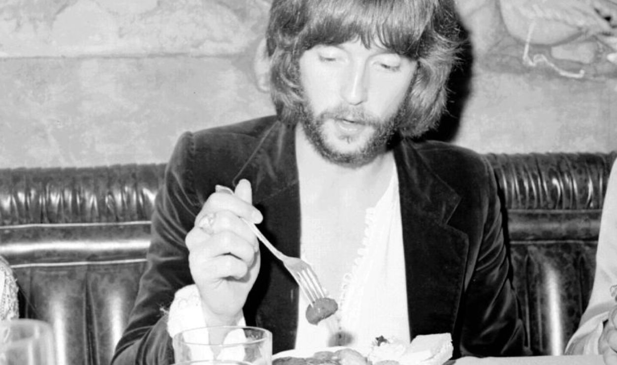LOS ANGELES - CIRCA 1970: Rock and roll guitarist Eric Clapton eats a meal at a restaurant in circa 1970 in Los Angeles, California. 