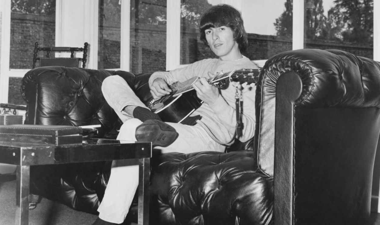 UNSPECIFIED - JANUARY 01: Georges Harrison Sitting And Playing Guitar During Sixties
