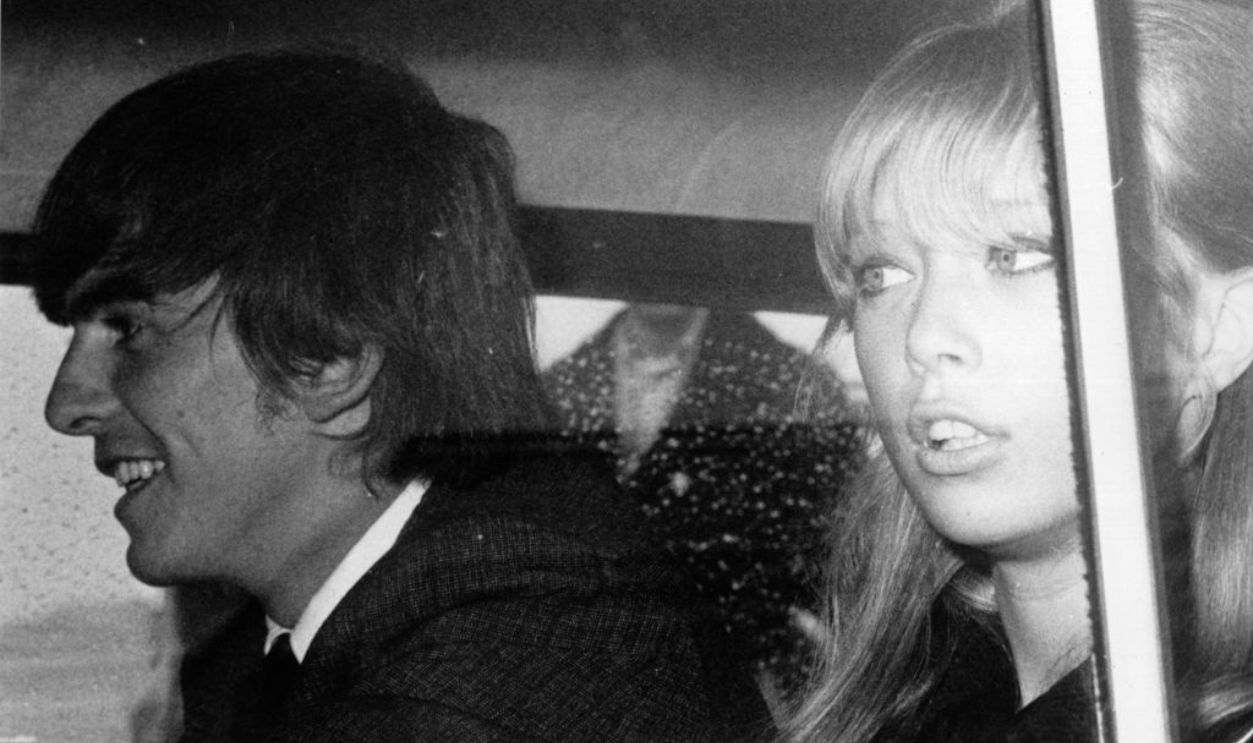 27th May 1964: George Harrison (1943 - 2001), of the pop group The Beatles, and his girlfriend Patti Boyd arrive back in Britain after a month-long holiday on an island in the South Seas with fellow Beatle John Lennon and his wife Cynthia.