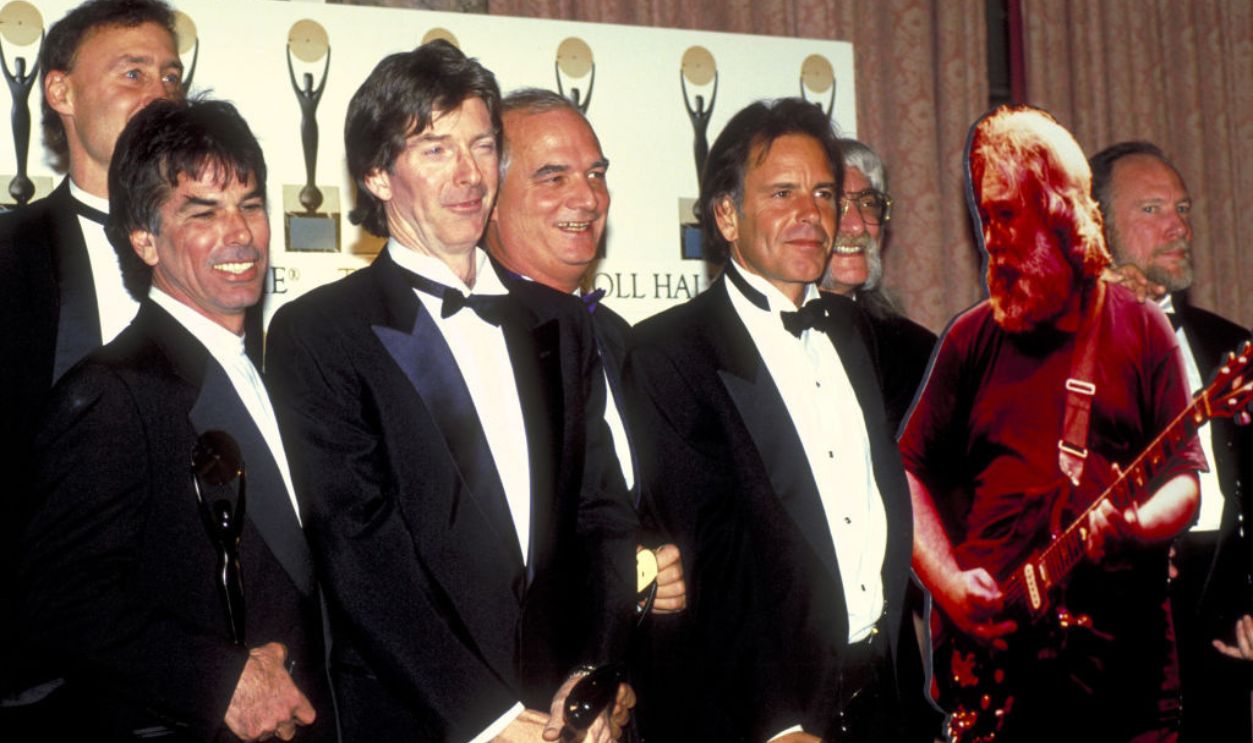 Bruce Hornsby, Mickey Hart, Phil Lesh, Bill Kreutzmann, Bob Weir, Tom Constanten (with cut-out standee of Jerry Garcia) and Vince Welnick of the Grateful Dead