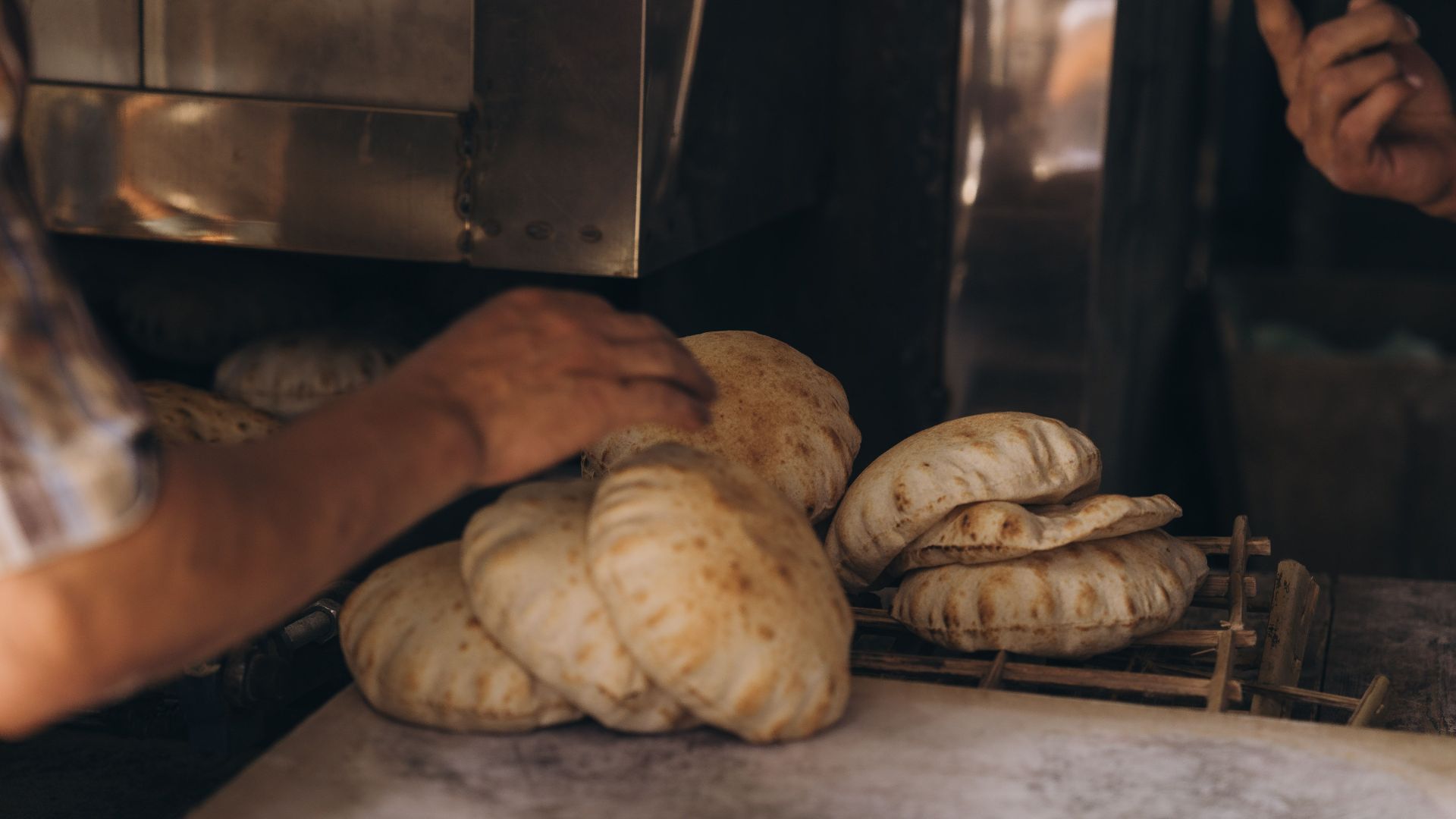Close-up of hands baking traditional Egyptian bread in an Alexandria bakery.