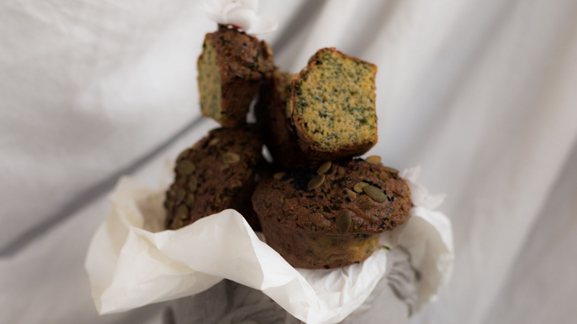Creative display of rustic muffins on a classical sculpture, styled with elegance.