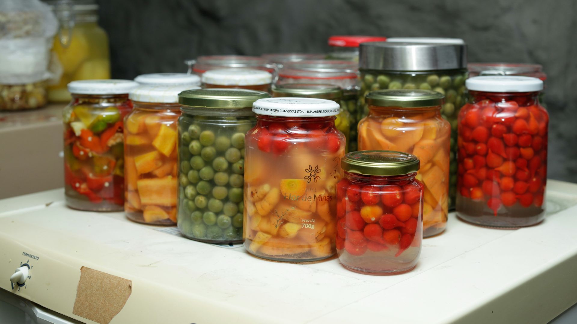 Jars of preserved vegetables and fruits on a shelf.