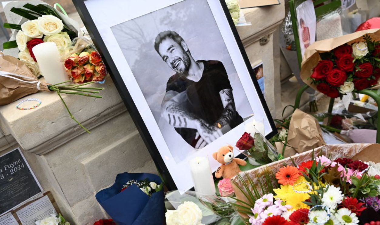 This photograph shows displayed flowers and a framed picture of late British singer Liam Payne as fans gather to pay tribute to the former member of the British pop band One Direction, at Jardin des Tuileries in Paris, on October 20, 2024. 