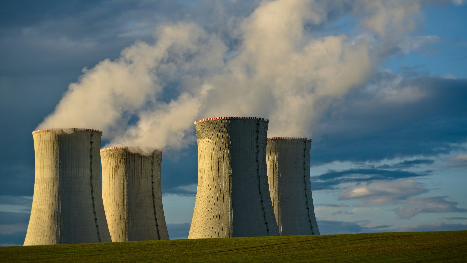 gray concrete towers under white clouds and blue sky during daytime