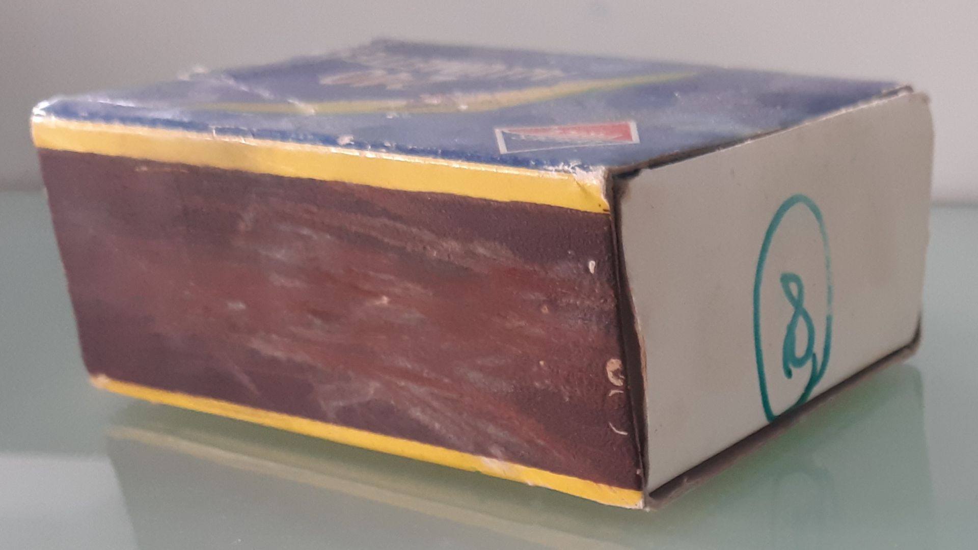 A candle (on the right), a match burned to the third (in the middle) and its box (on the left) lying on a laboratory bench. Picture taken on April, 26th 2024 at 9:24 AM with a Samsung Galaxy A40 smartphone in Orsay.