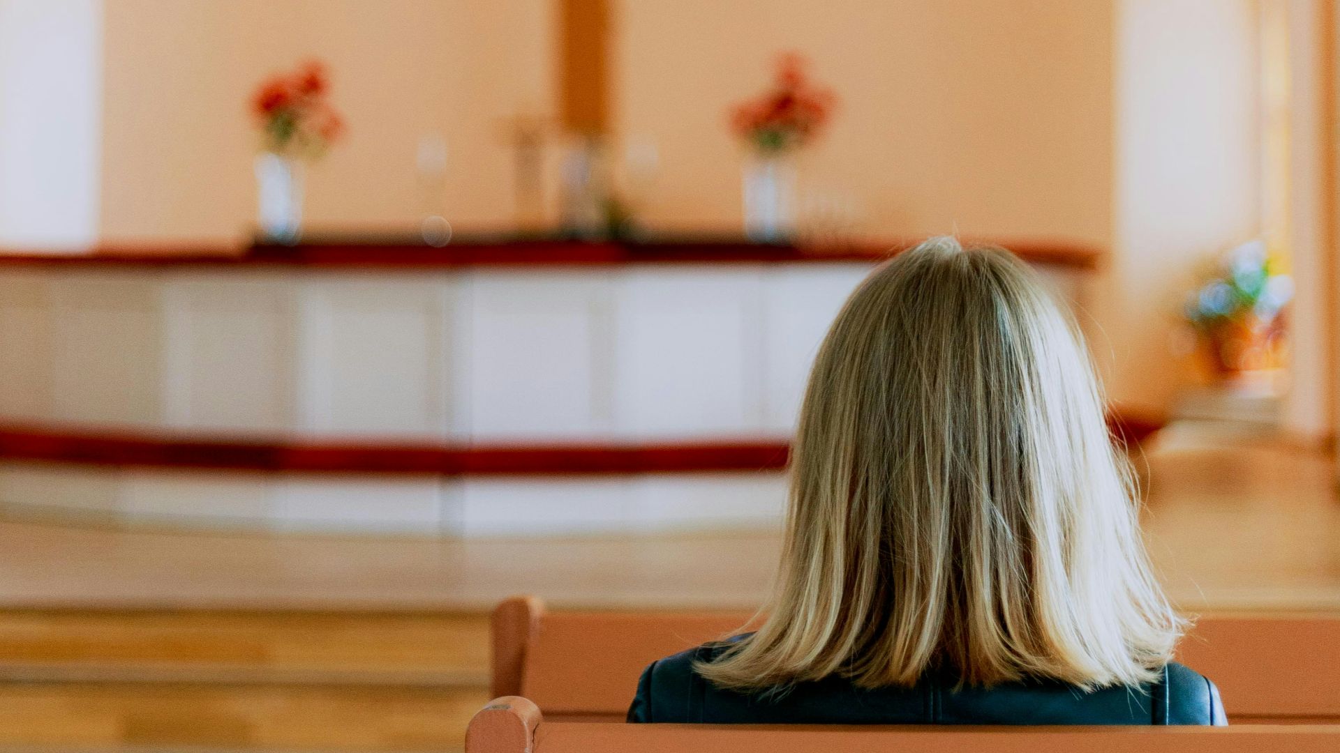 woman in blue shirt sitting on brown wooden bench