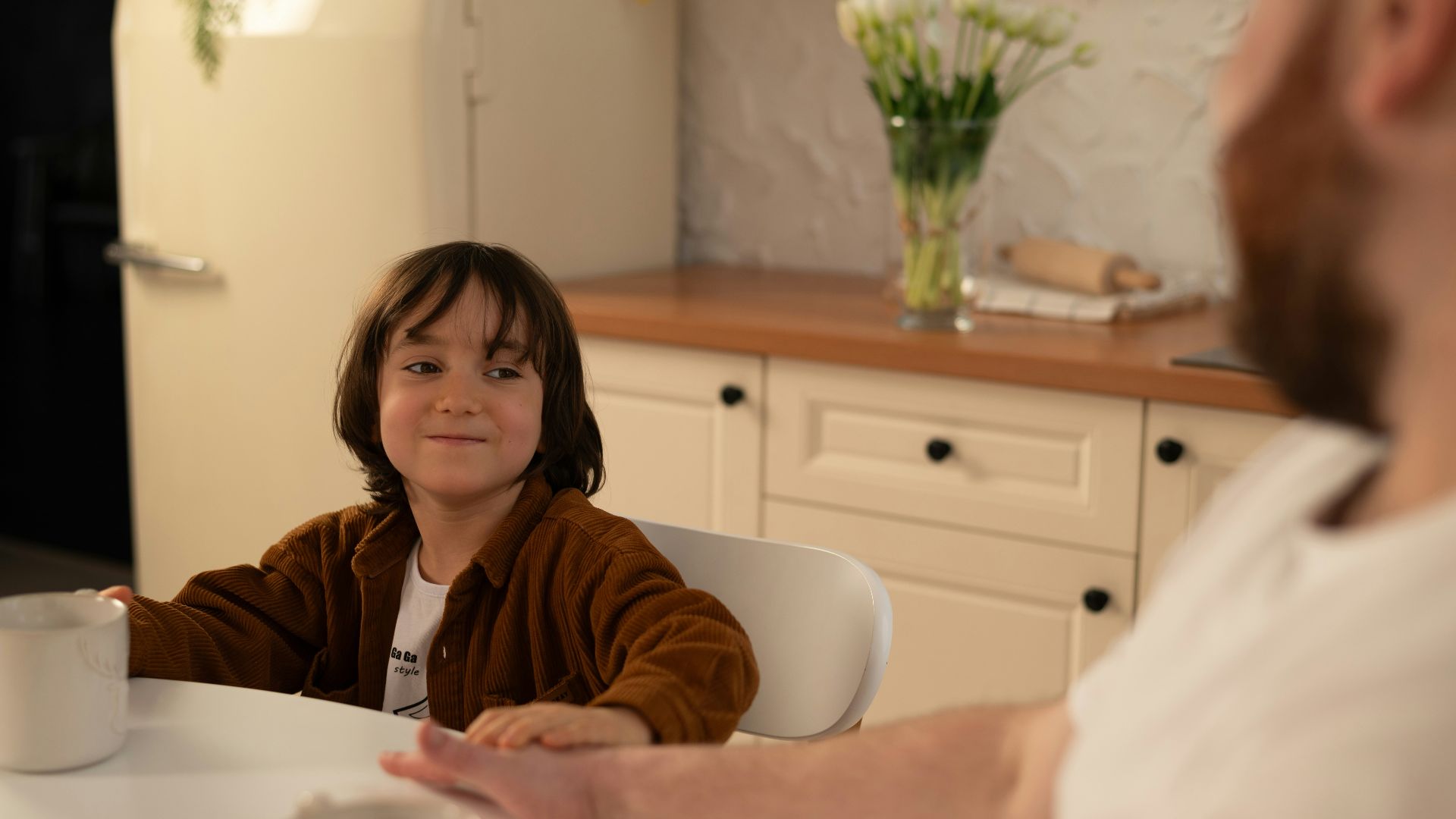 a little girl sitting at a table with a man