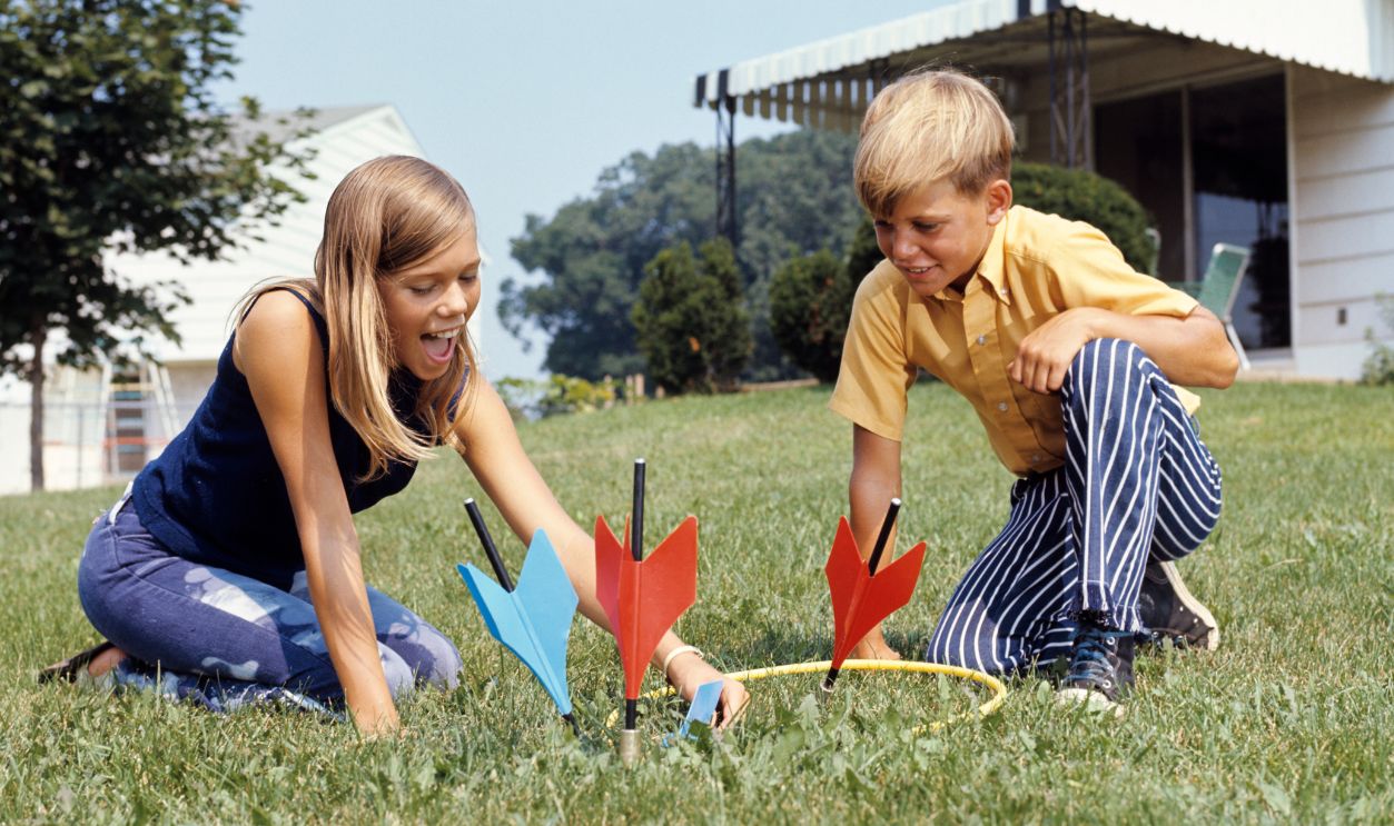 1970s BOY GIRL PLAYING... 1970s BOY GIRL PLAYING LAWN DARTS GAME IN BACKYARD