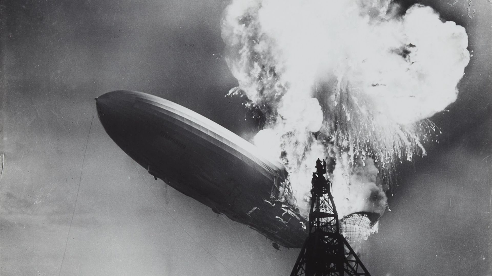 The German airship (zeppelin) Hindenburg on fire at the mooring mast at Lakehurst New Jersey, United States of America, 6 May 1937. Ballast water is being dropped. The end of the airships.