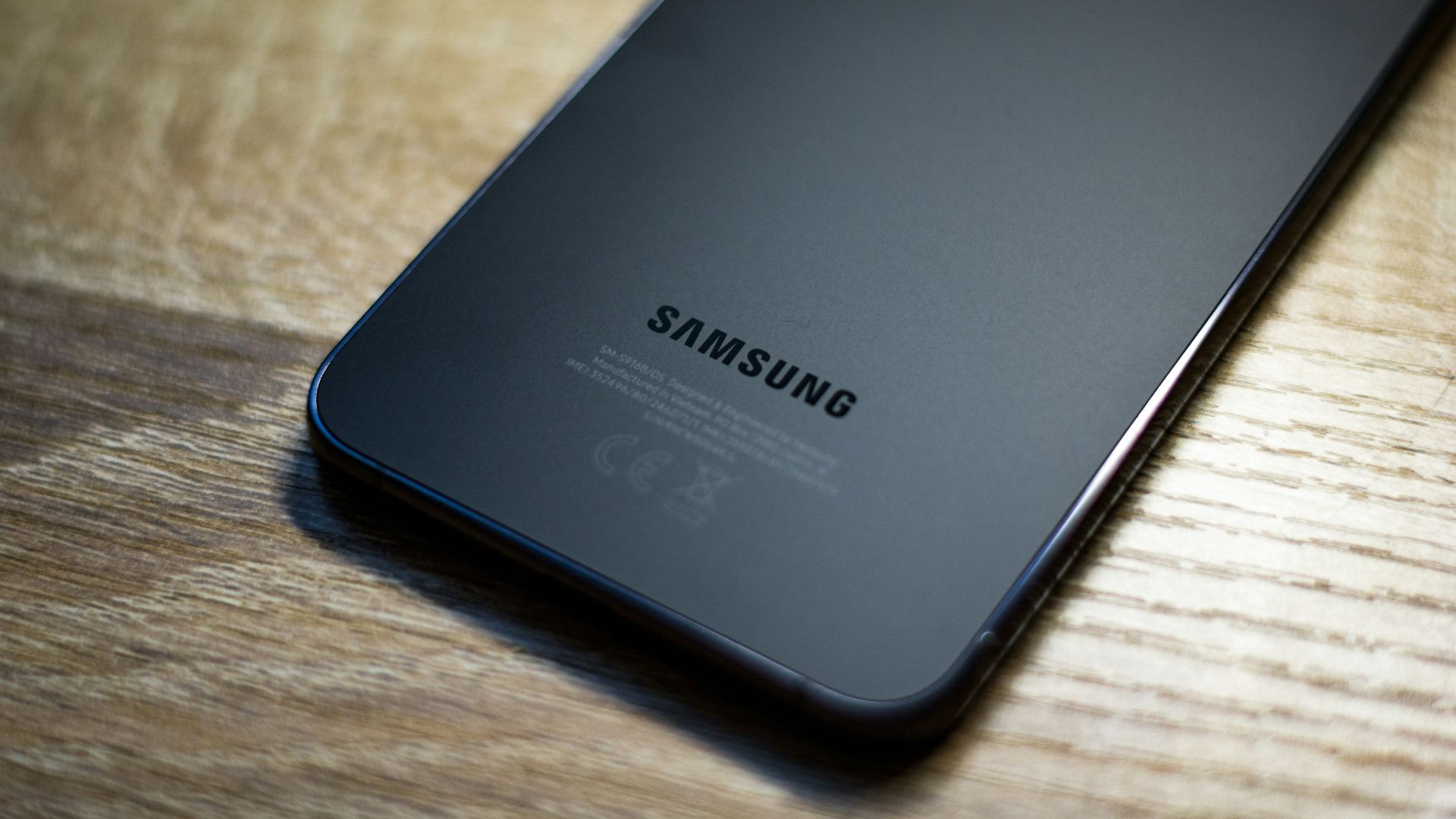 a close up of a samsung phone on a wooden table