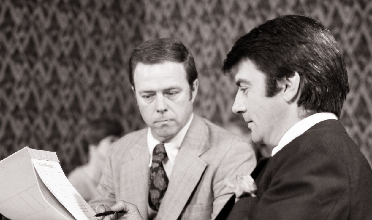 1970s Two Men Reviewing Doc... 1970s Two men reviewing documents at business lunch in a restaurant.