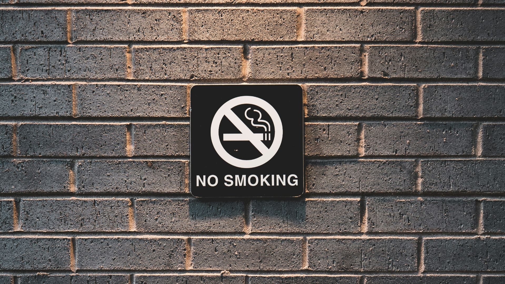 no smoking sign on brick wall