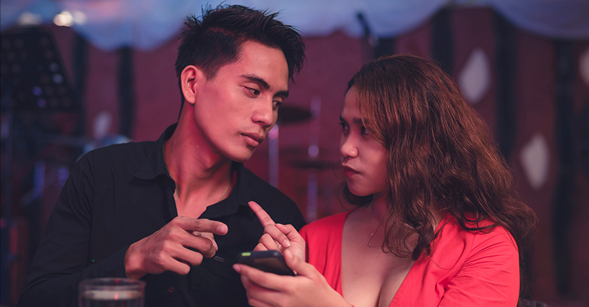 Man and woman pointing at each other