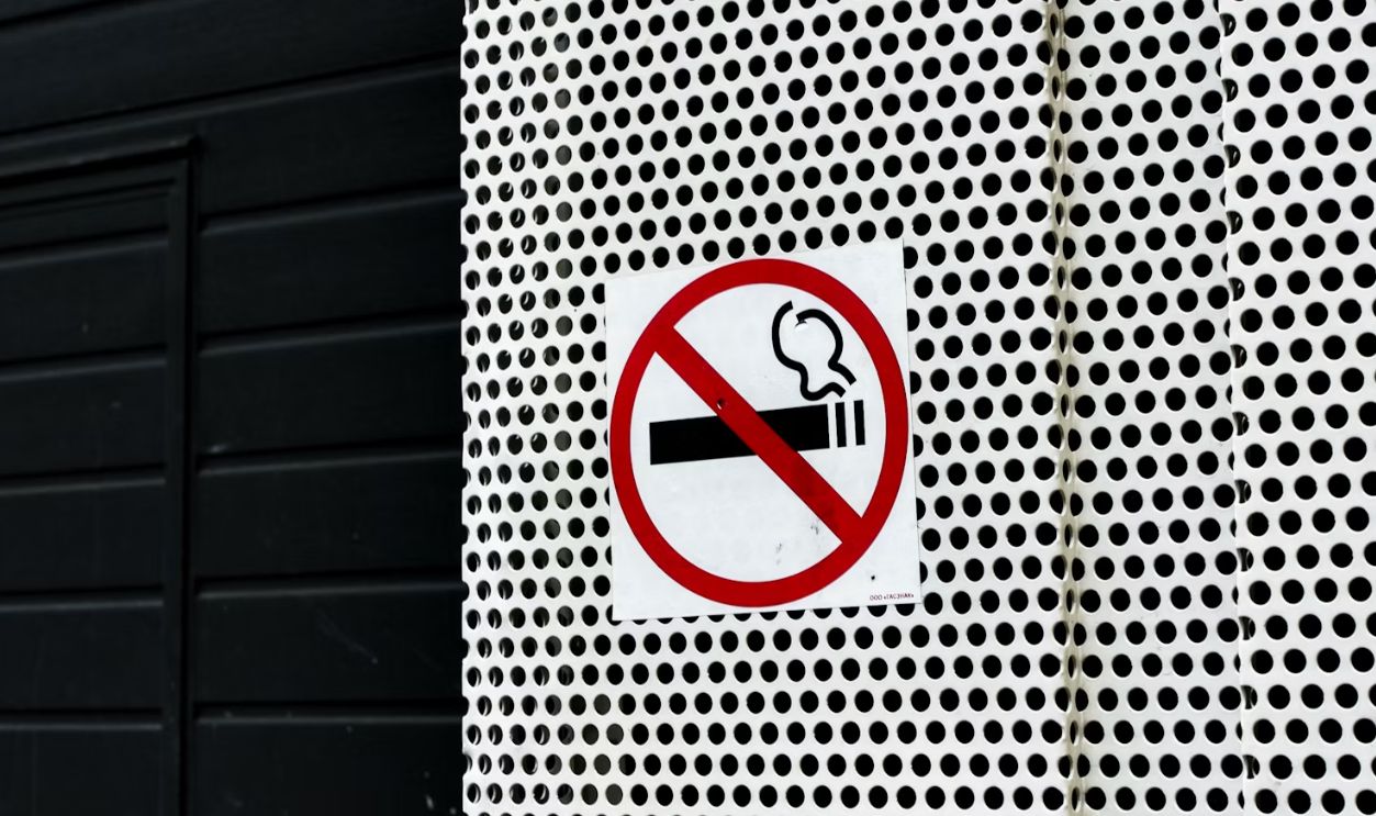 No smoking sign on a textured wall.