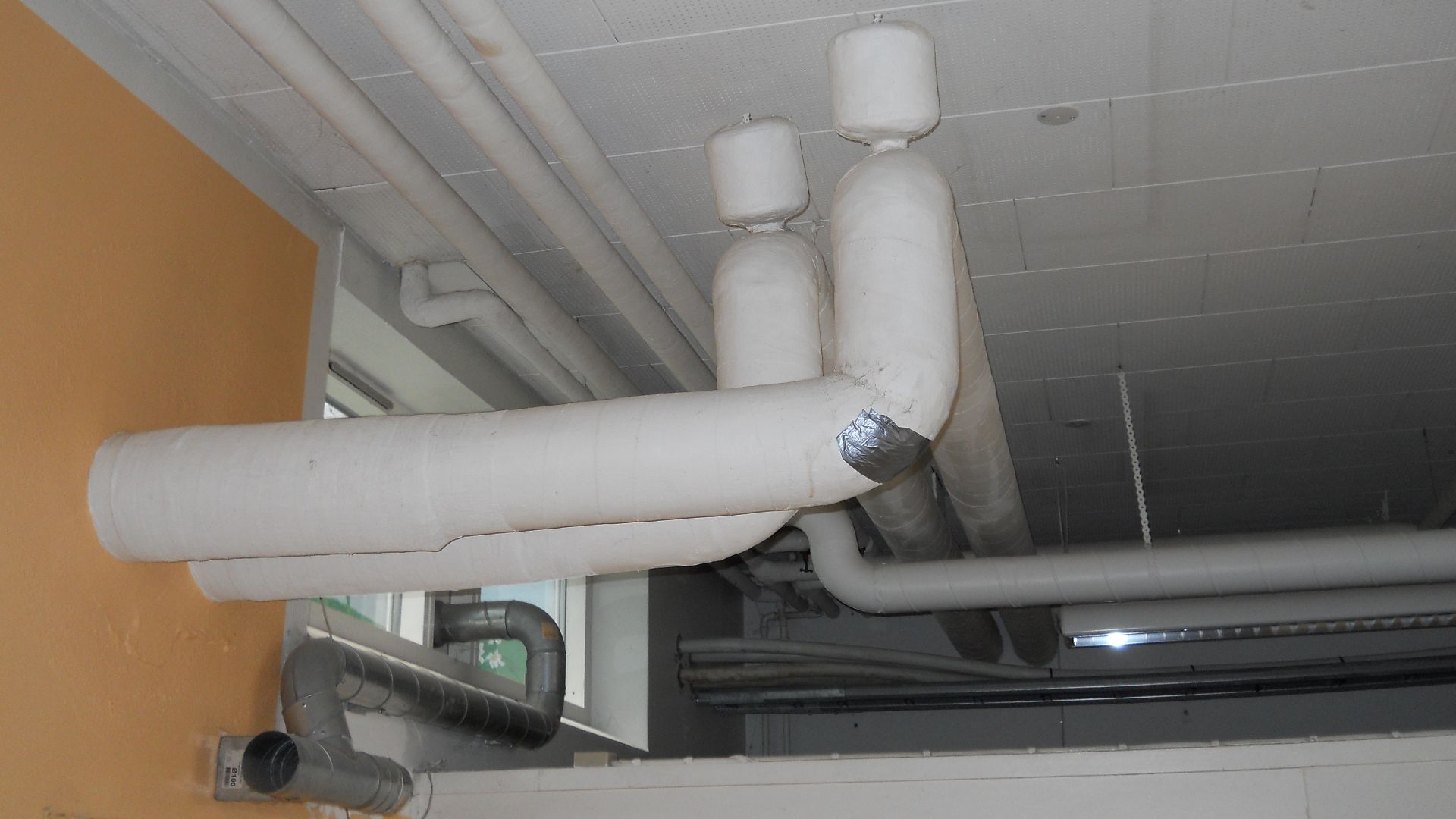 Thermal insulation of a pipe. The insulation is made from asbestos fibres.