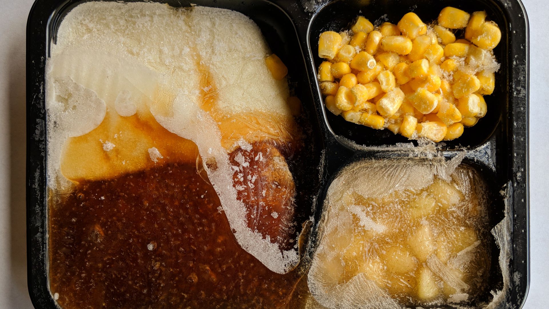 Top view of an opened, uncooked TV dinner.