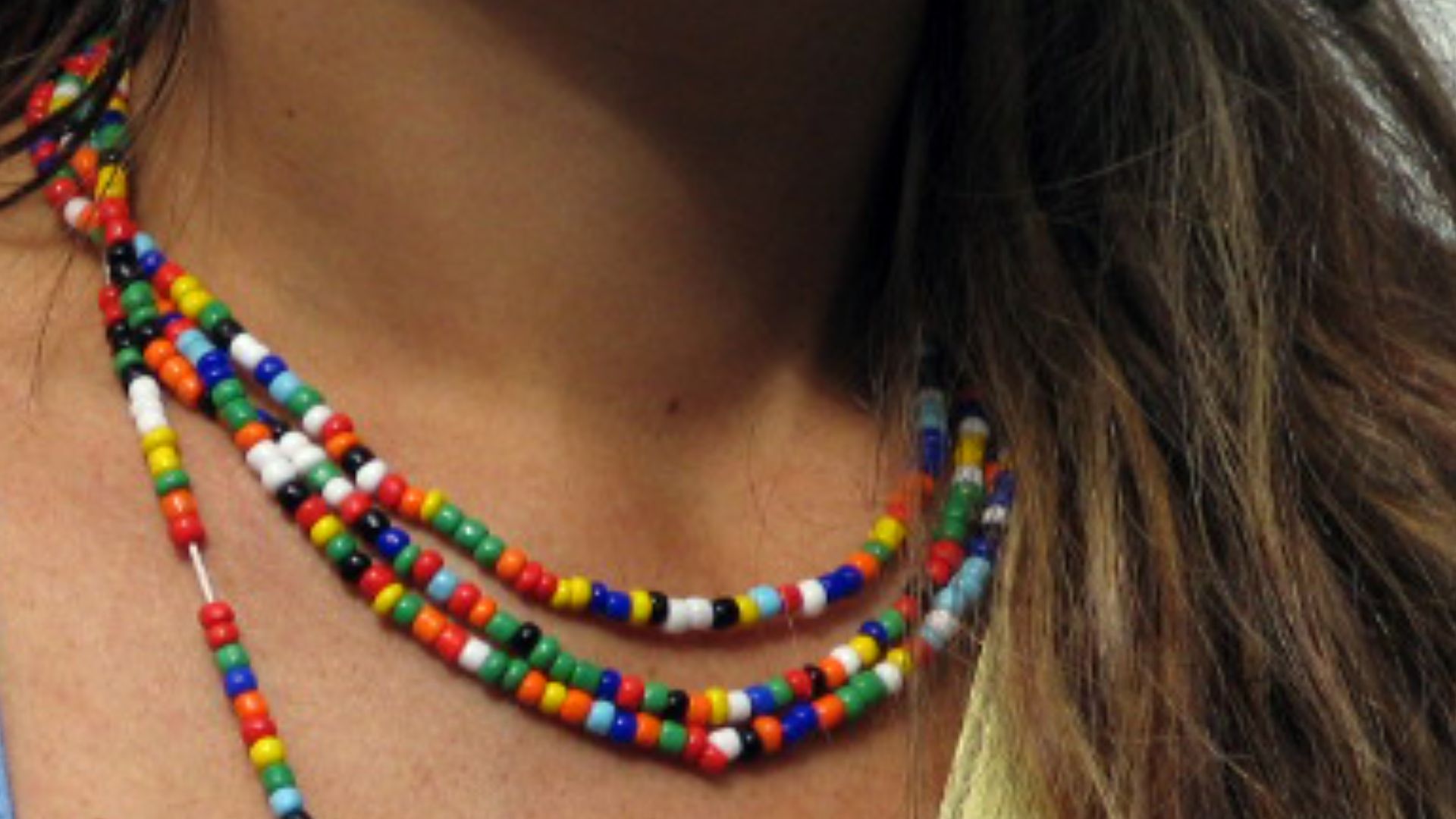 A young woman wearing a colorful bead necklace.