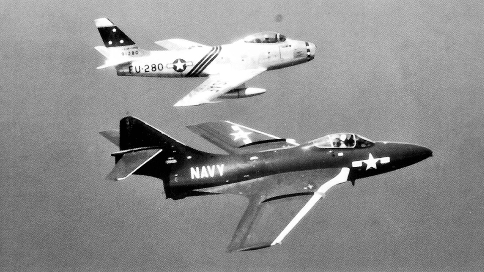 75th Fighter-Interceptor Squadron North American F-86A-5-NA Sabre 49-1280 flying with a Navy Grumman F9F-6 Cougar over Long Island, 1952.   The F9F-6 Cougar was the first F9F variant with swept wings