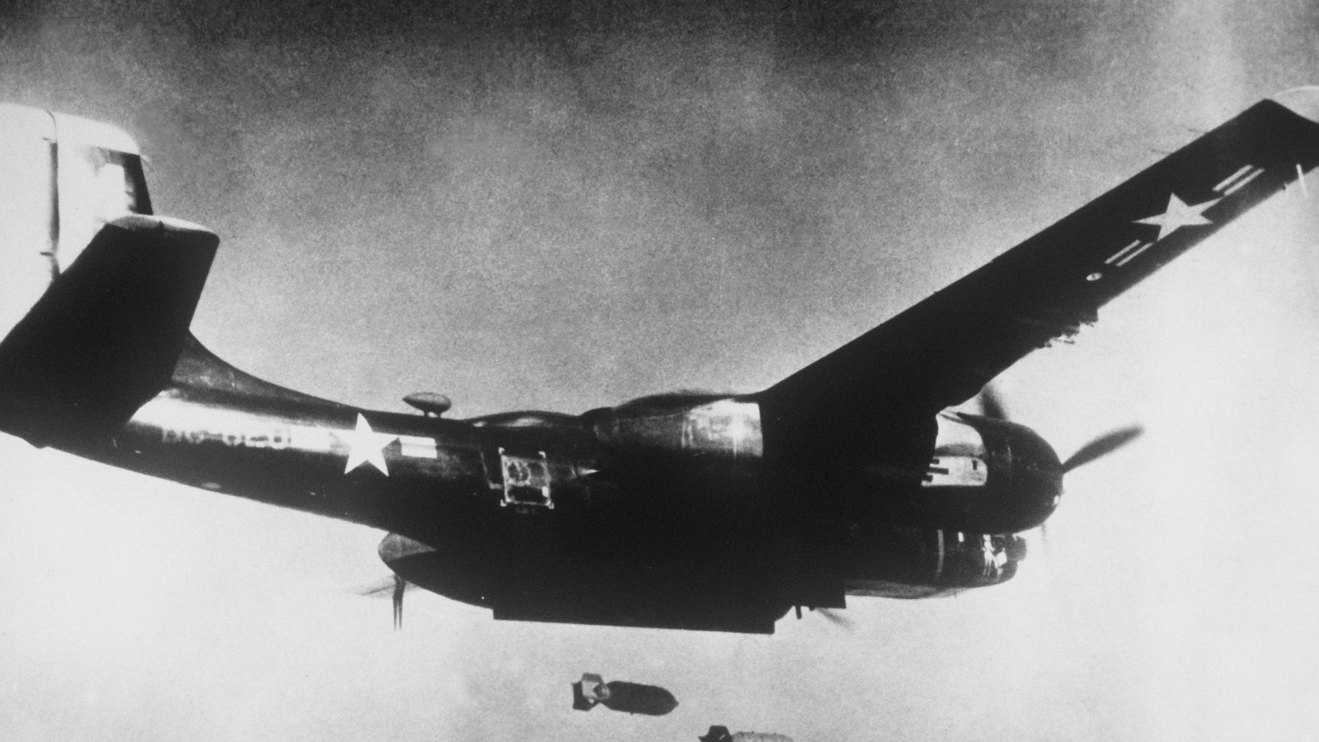 A black painted U.S. Air Force Douglas B-26C Invader dropping bombs during the Korean War in 1953. The Invader was assigned to the 3rd Bomb Wing, 5th Air Force.Original caption: