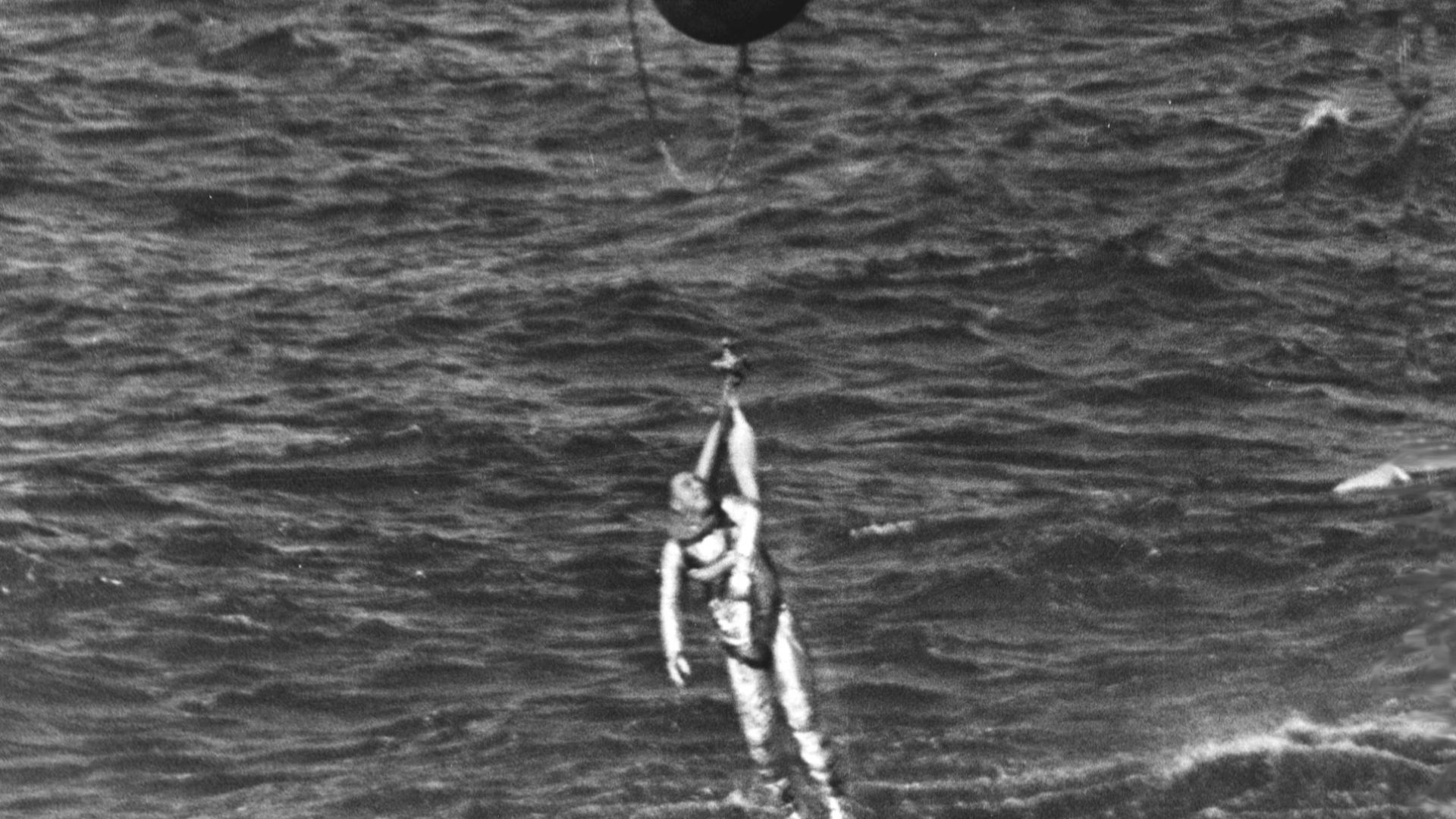 Marine helicopter has astronaut Virgil I. Grissom in harness and is bringing him up out of the water. The Liberty Bell 7 spacecraft has just sunk below the water. His Mercury-Redstone 4 launch was the second in the U.S. manned space effort. The helicopter
