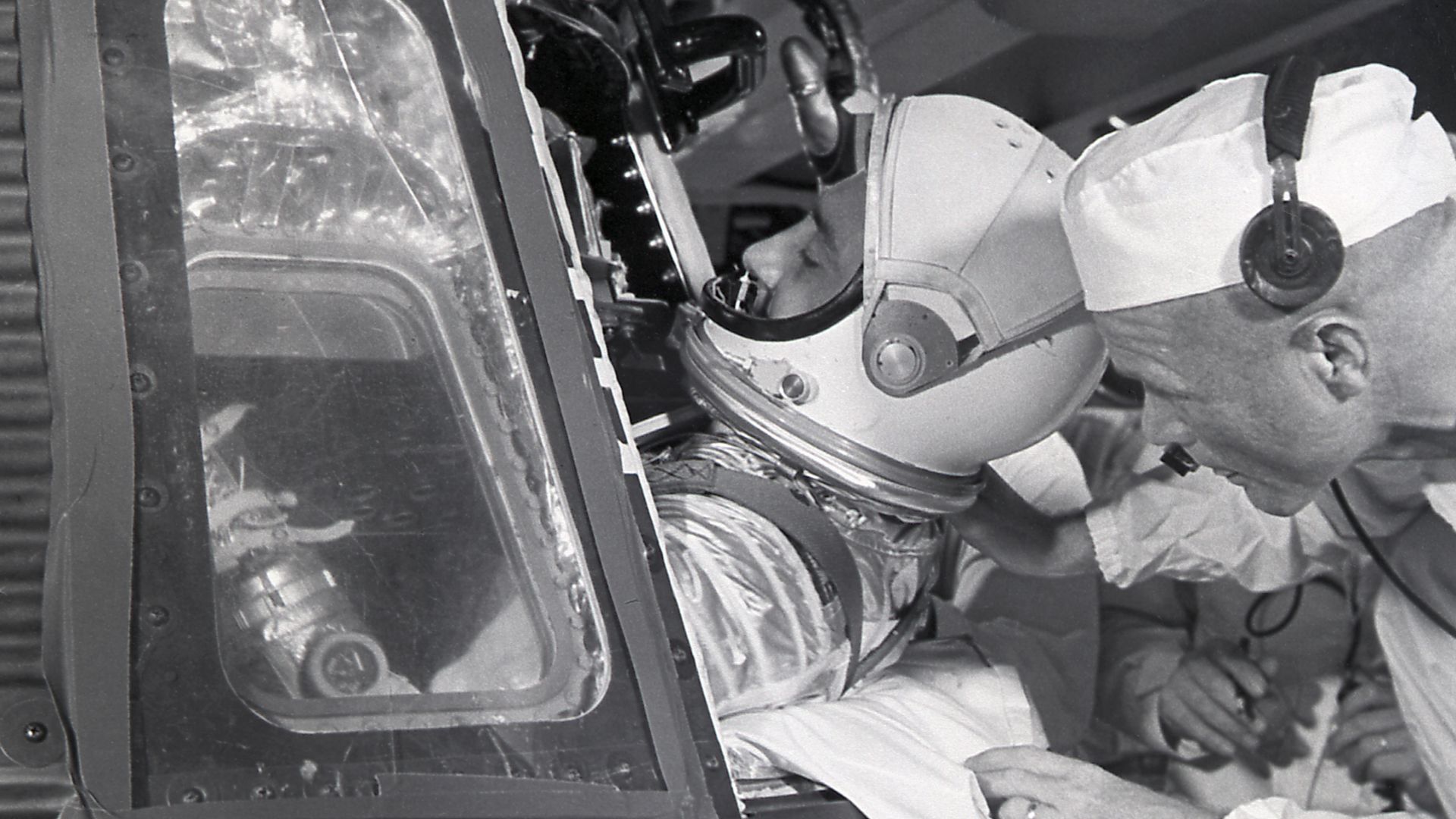 Assisted by astronaut John Glenn, astronaut Virgil Grissom enters the Mercury capsule, Liberty Bell 7, for the MR-4 mission on July 21, 1961. Boosted by the Mercury-Redstone vehicle, the MR-4 mission was the second manned suborbital flight.