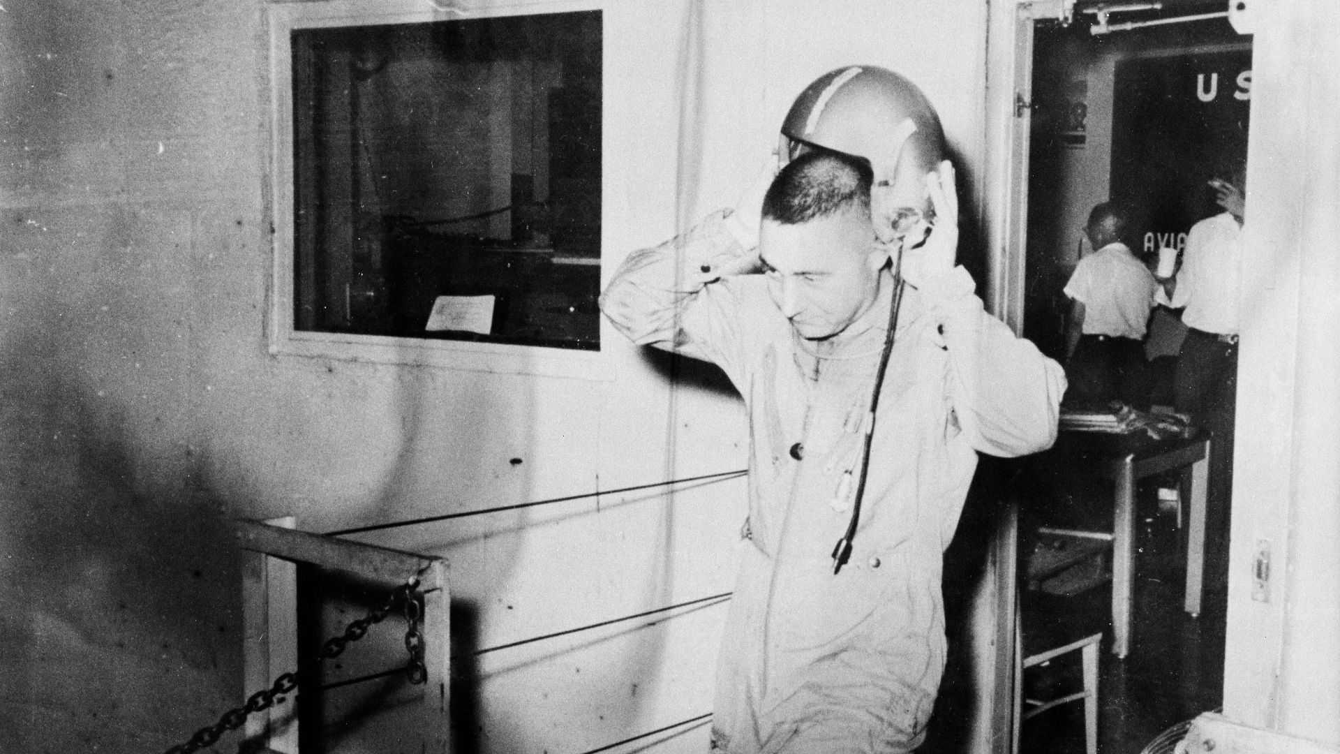 B59-00587 (1959) --- Astronaut Virgil (Gus) Grissom is pictured leaving a U.S. Navy installation and removing his helmet. Photo credit: NASA
