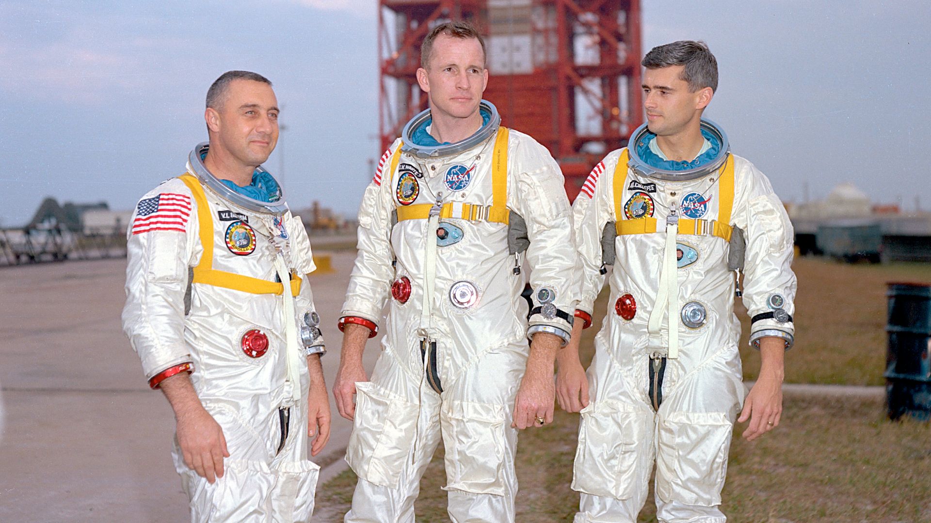 Astronauts (left to right) Gus Grissom, Ed White, and Roger Chaffee, pose in front of Launch Complex 34 which is housing their Saturn 1 launch vehicle. The astronauts died ten days later in a fire on the launch pad.