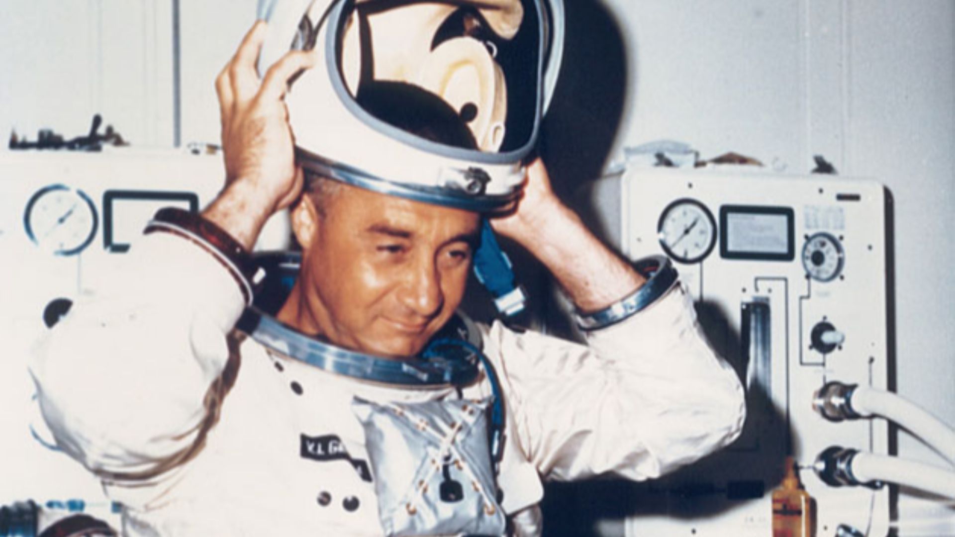 Astronaut Virgil I. Grissom dons his helmet prior to the first manned altitude chamber test of the Apollo 204 spacecraft at the Kennedy Space Center in Florida.