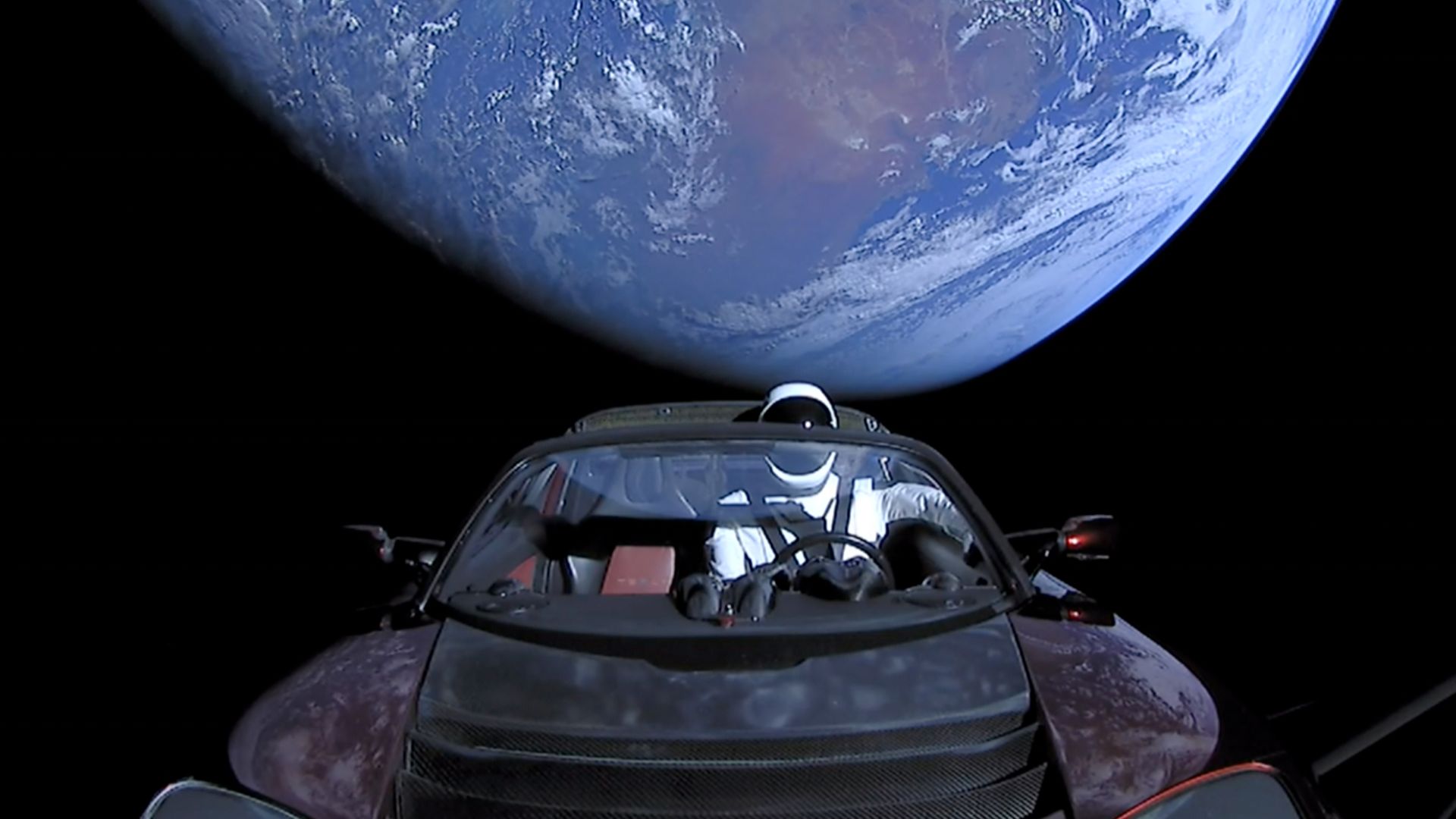 Elon Musk's Tesla Roadster, with Earth in background.