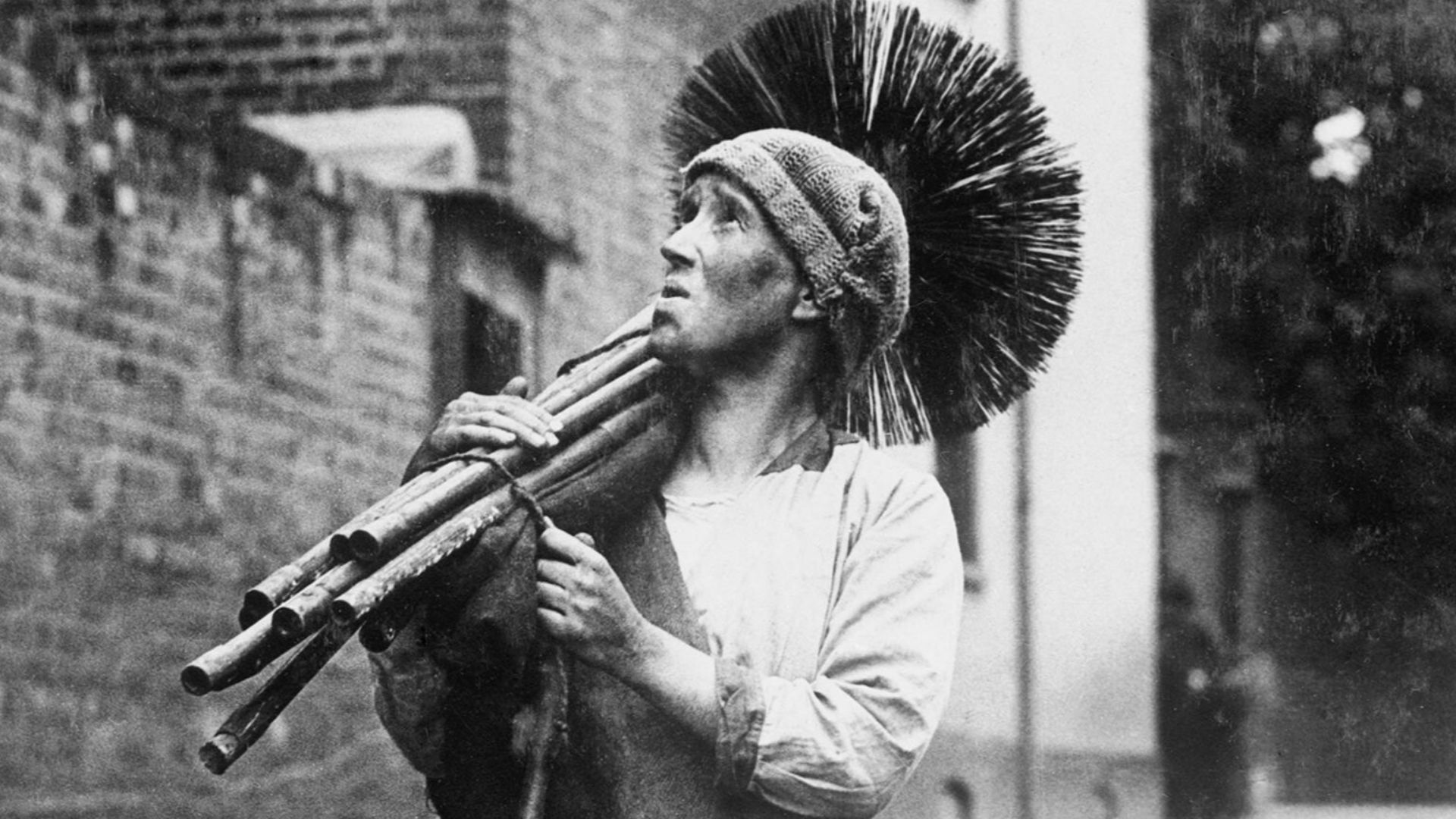 Women at work during the First World War
Mrs Rosanna Forster from Kent is a chimney sweep, carrying on her husband's business while he serves abroad.  Here, she walks along a road, her brooms over her shoulder.