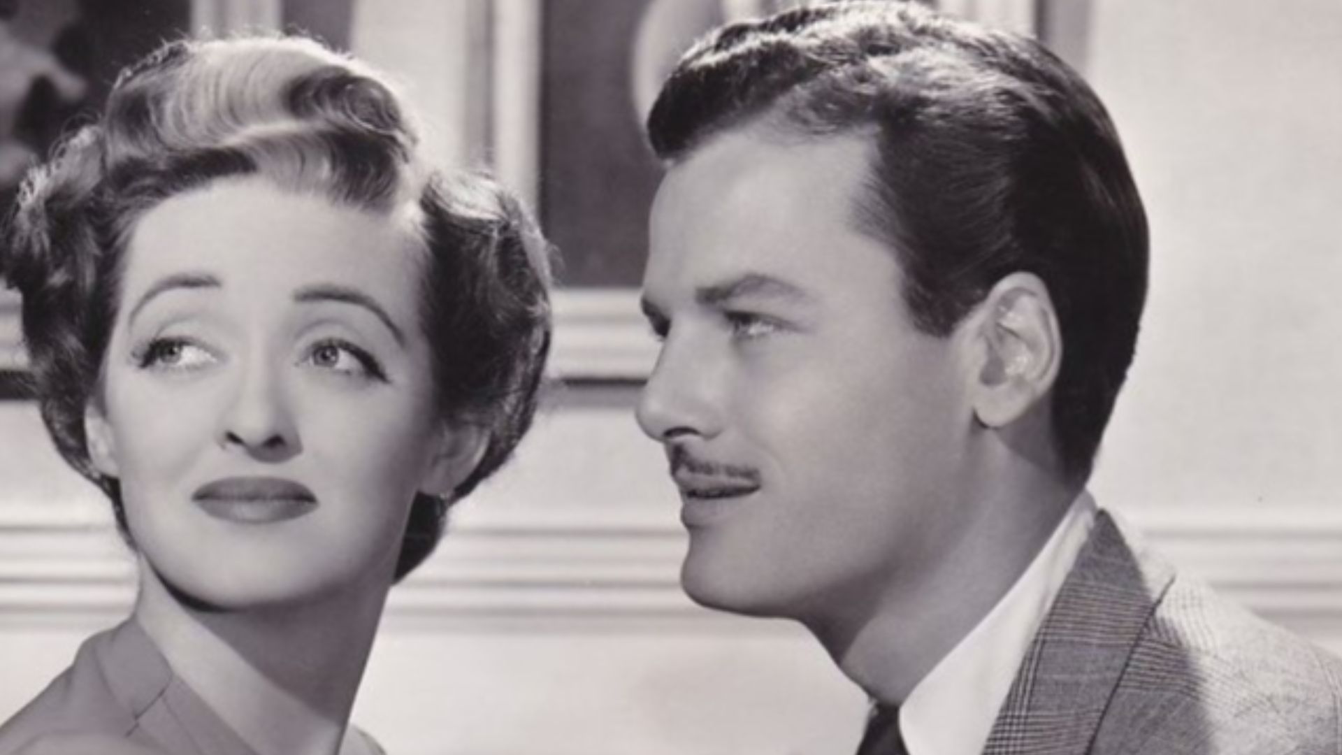 Bette Davis and Gig Young in Old Acquaintance, 1943. Vintage 1943 portrait photo issued by Warner Bros. studio for the film OLD ACQUAINTANCE. The original BERT SIX studio photographer stamp is on the rear of the photo