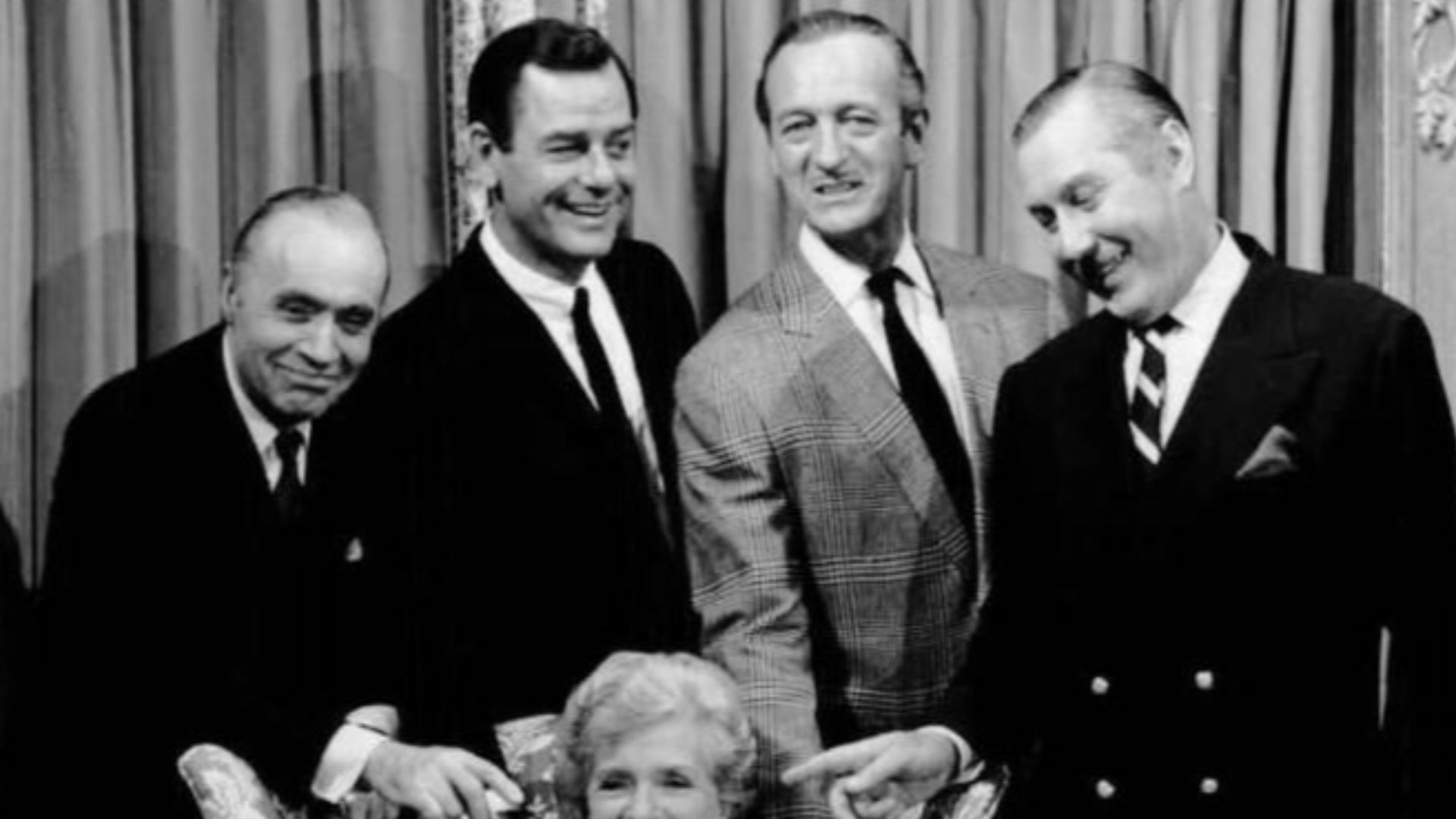 Cast photo of the television program The Rogues.  Seated with the bulldog is Gladys Cooper