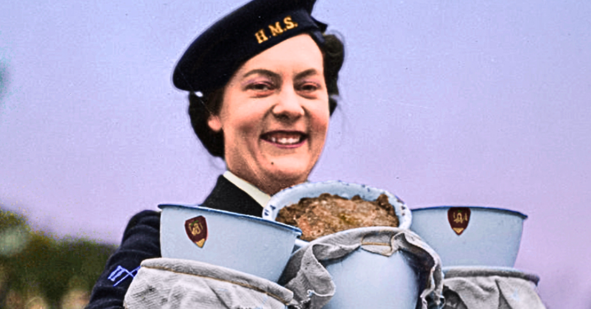 A Woman Royal Navy Services signals operator holding recently cooked Christmas puddings at Greenock, 19 December 1942.