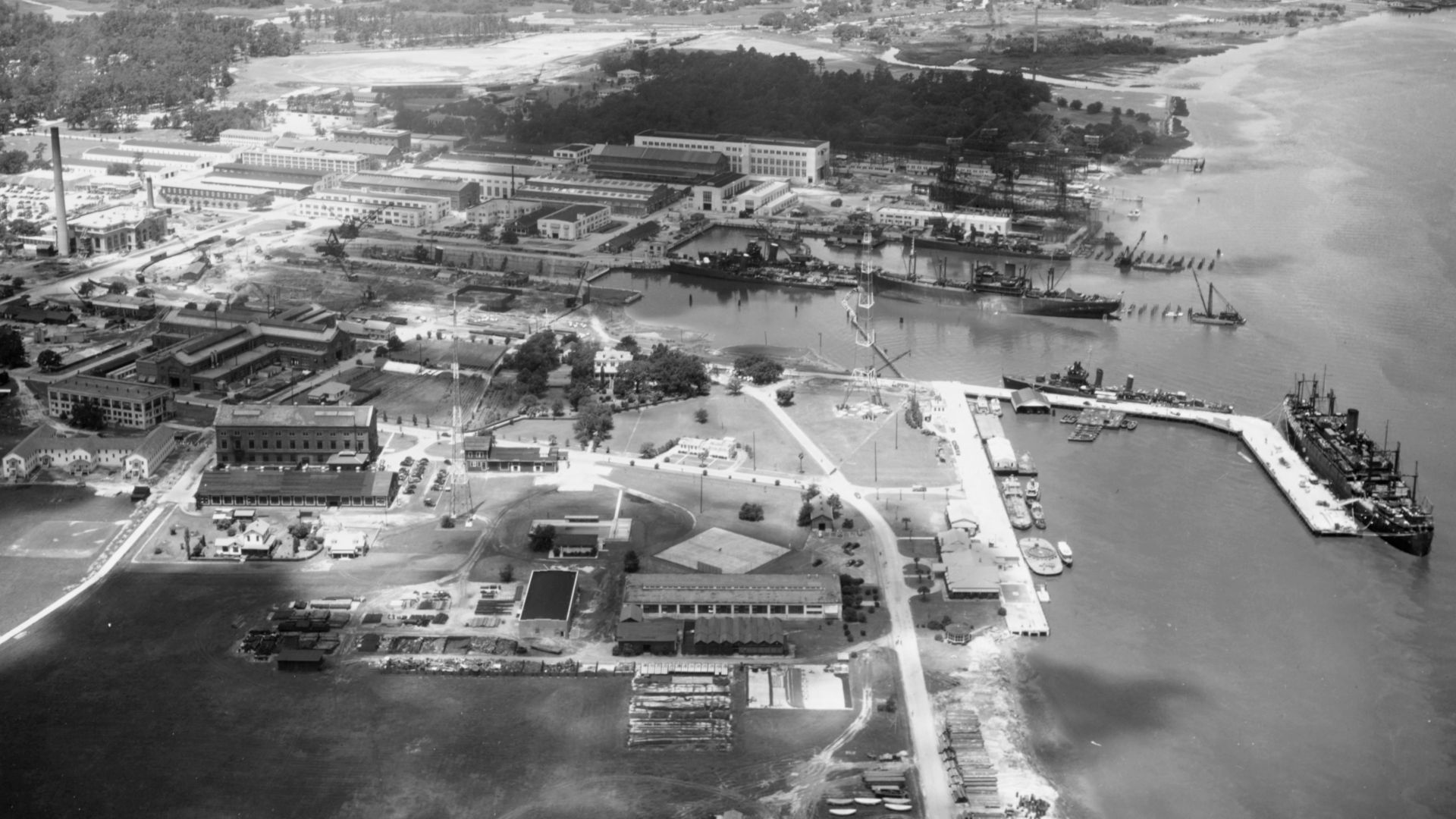 The U.S. Charleston Naval Shiyard, South Carolina (USA), preparing ships for war in 1941. The large ship on the right is probably USS Leonard Wood (AP-25), converting from an Army transport. The freighter is probably USS Hamul (AK-20), converting from a m